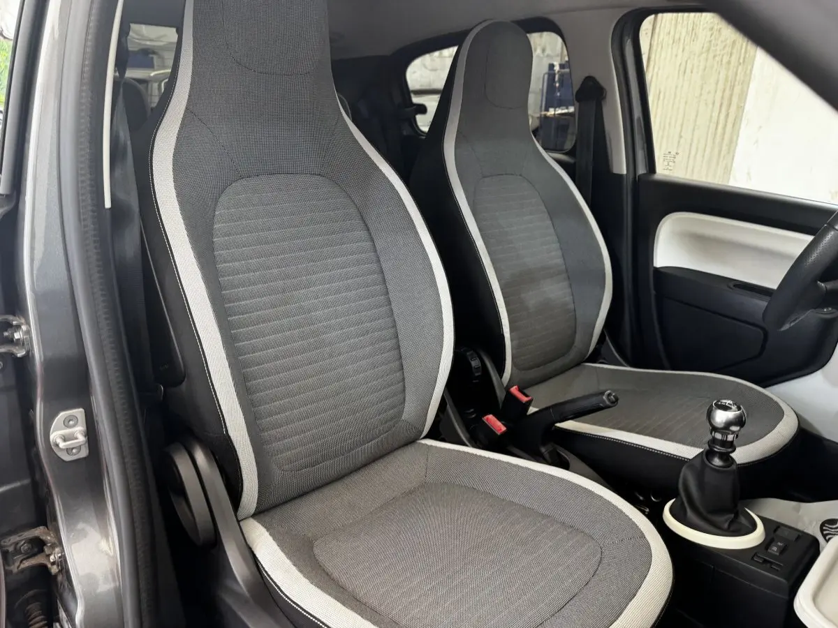 Vue intérieure des sièges avant gris clair et foncé de la Renault Twingo Intense Energy TCe 90 avec levier de vitesse manuel.