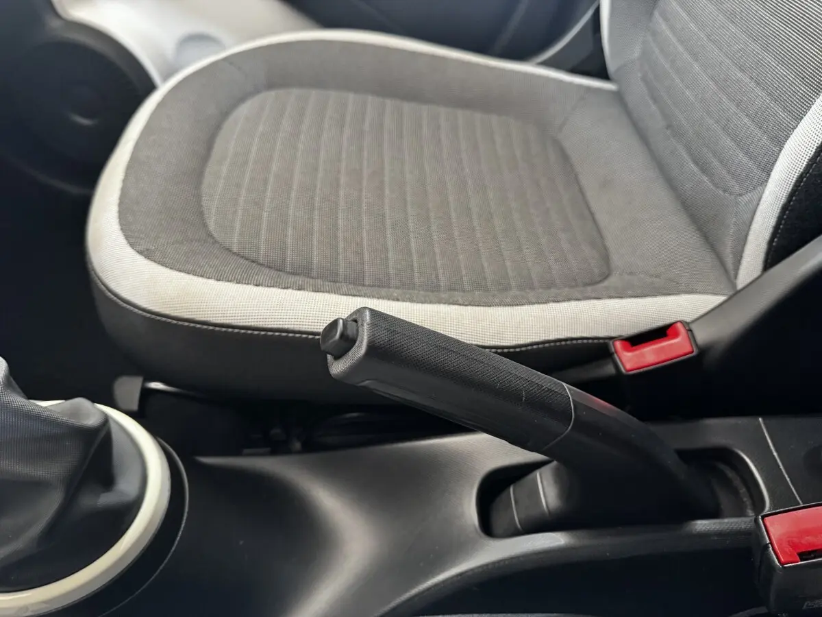 Gros plan sur le frein à main et siège avant gris clair et foncé de la Renault Twingo Intense Energy TCe 90 de 2016.