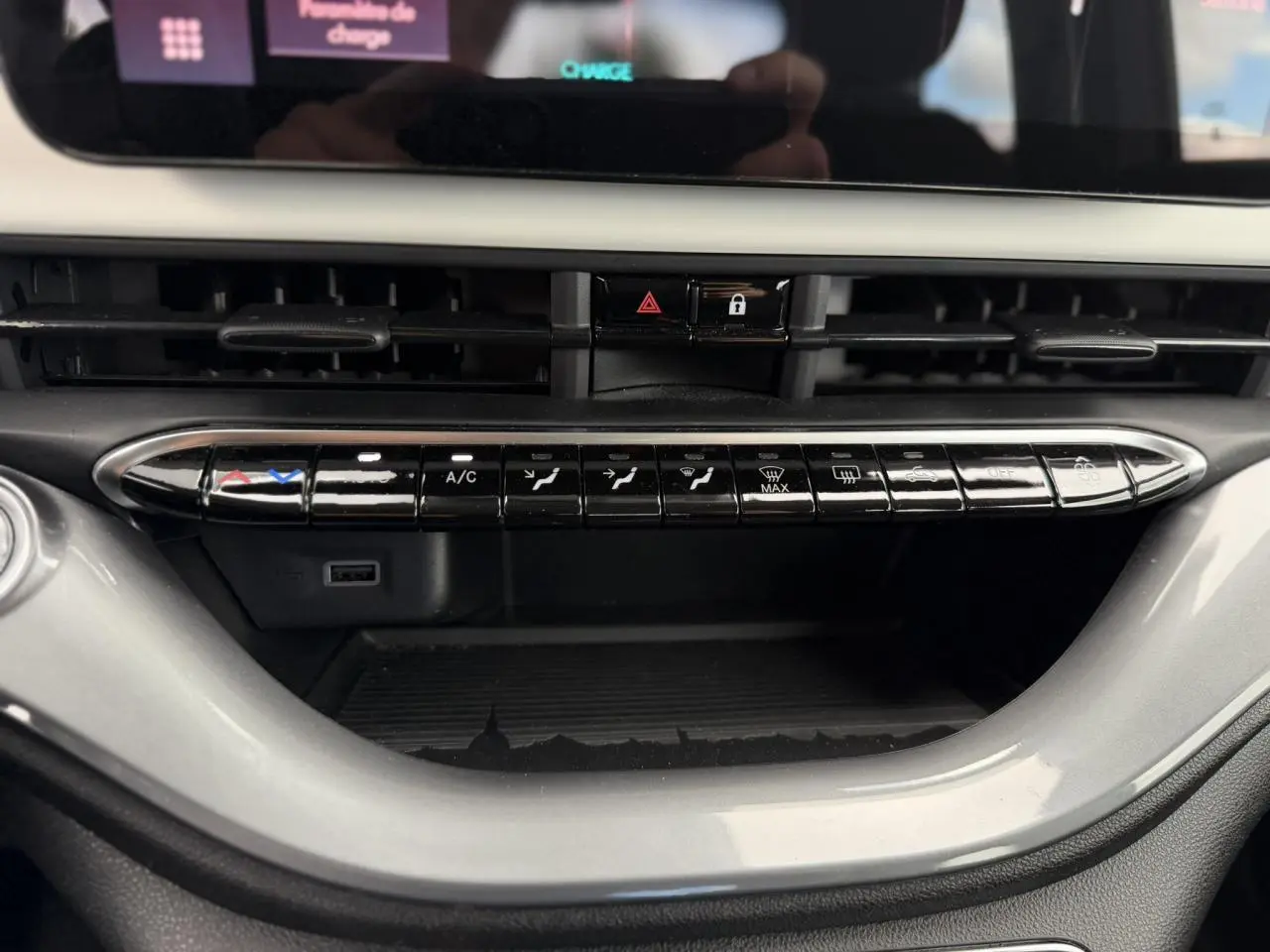 Vue rapprochée de la console centrale du Fiat 500 électrique blanc Arctic, montrant les commandes de climatisation et ventilation.