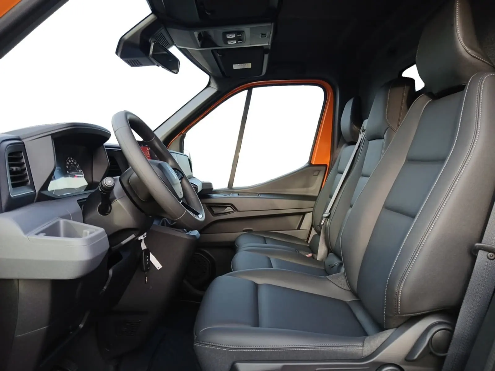 Vue intérieure côté conducteur du Renault Master orange 2026, avec banquette passager trois places en cuir noir.