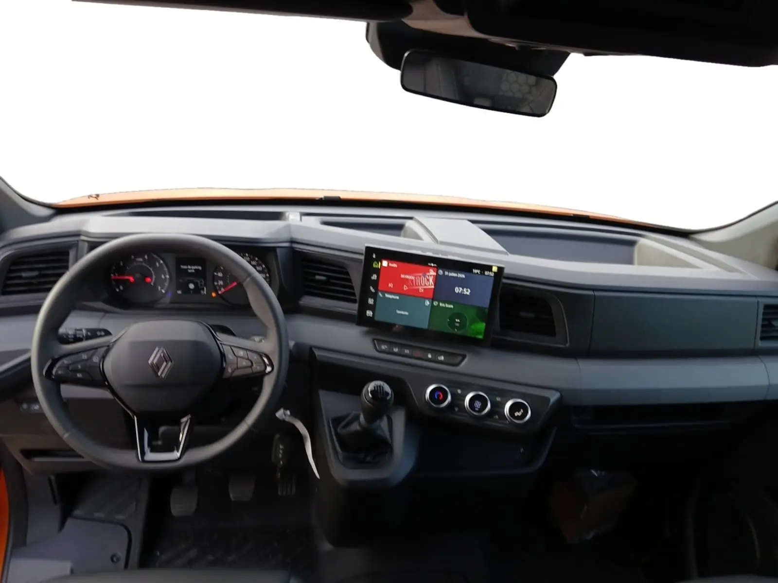 Vue intérieure avant du Renault Master orange 2026, tableau de bord avec écran tactile et volant multifonction.