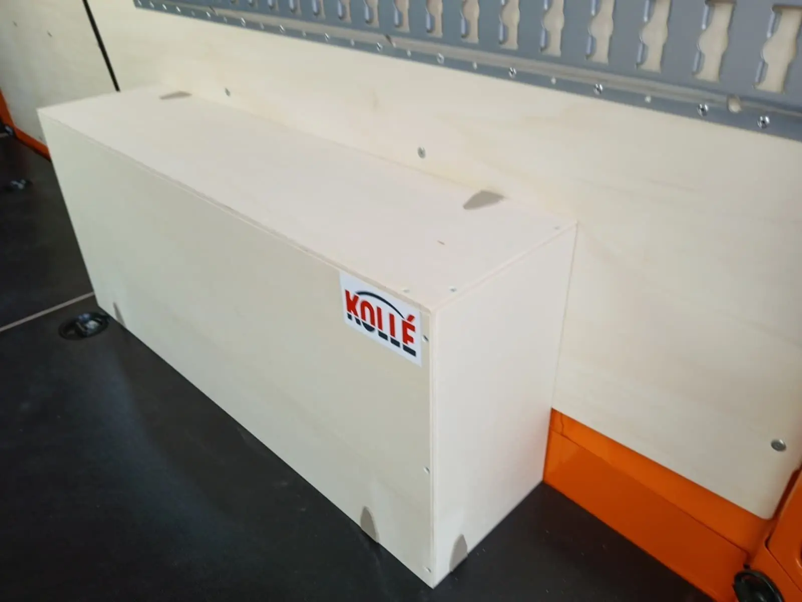 Détail intérieur montrant un coffre en bois clair fixé sur la paroi orange du Renault Master L2H2 2026.