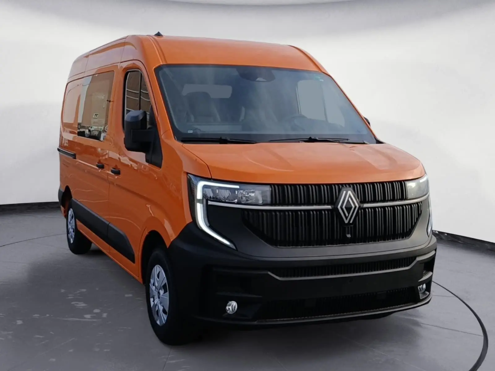 Renault Master orange en 3/4 avant droit, avec calandre noire marquée et phares LED en forme de C.