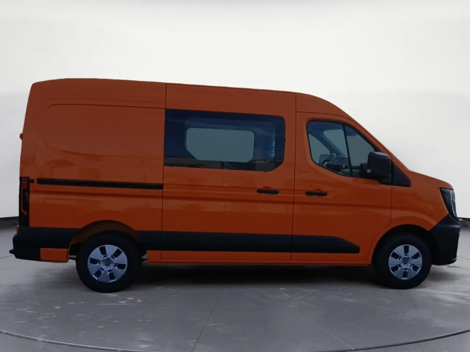 Vue de profil côté gauche du Renault Master L2H2 orange avec fenêtre latérale et protections noires.