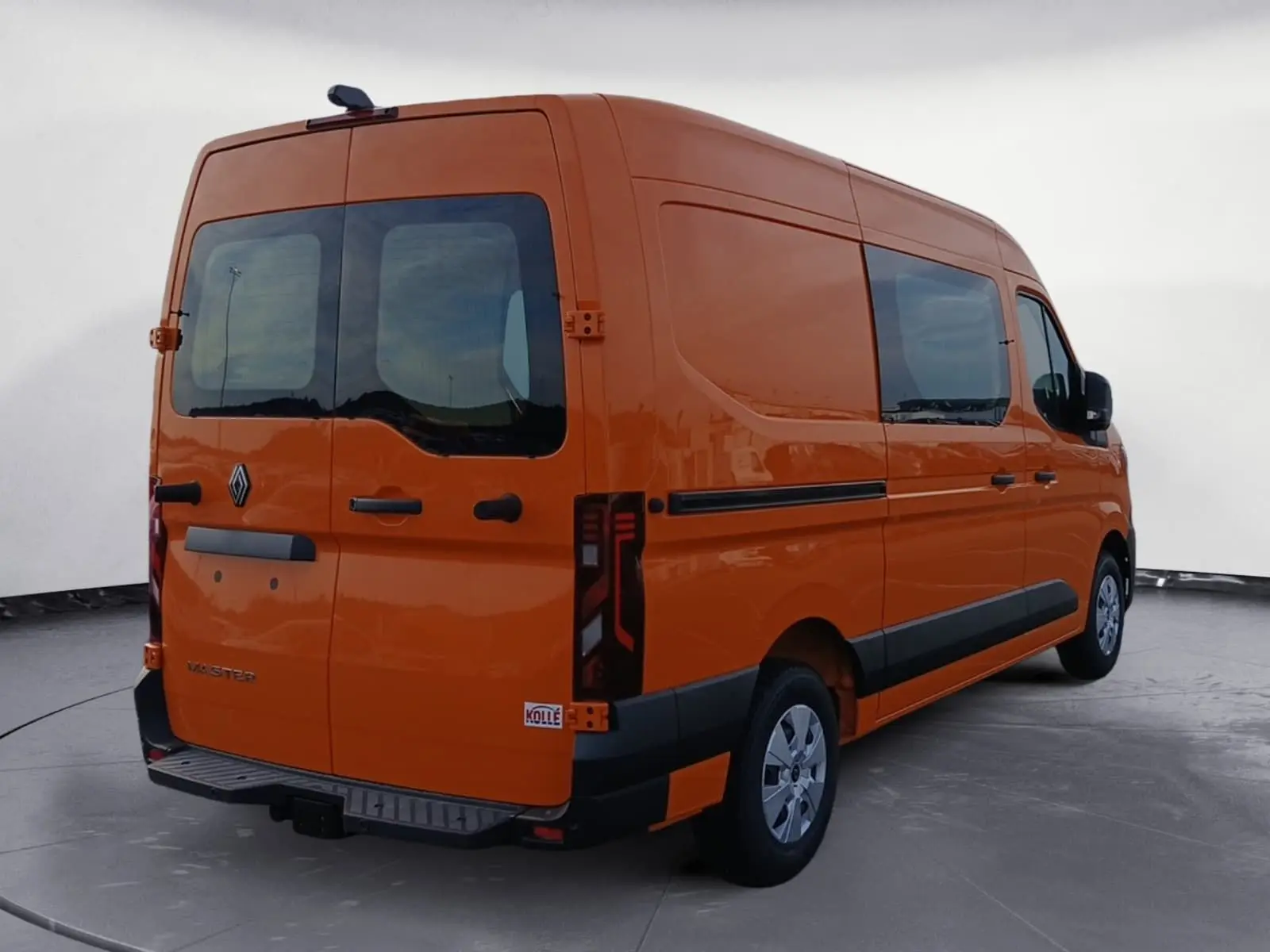 Vue 3/4 arrière droite d’un Renault Master orange avec vitres arrière et latérales, marchepied et feux arrière verticaux.