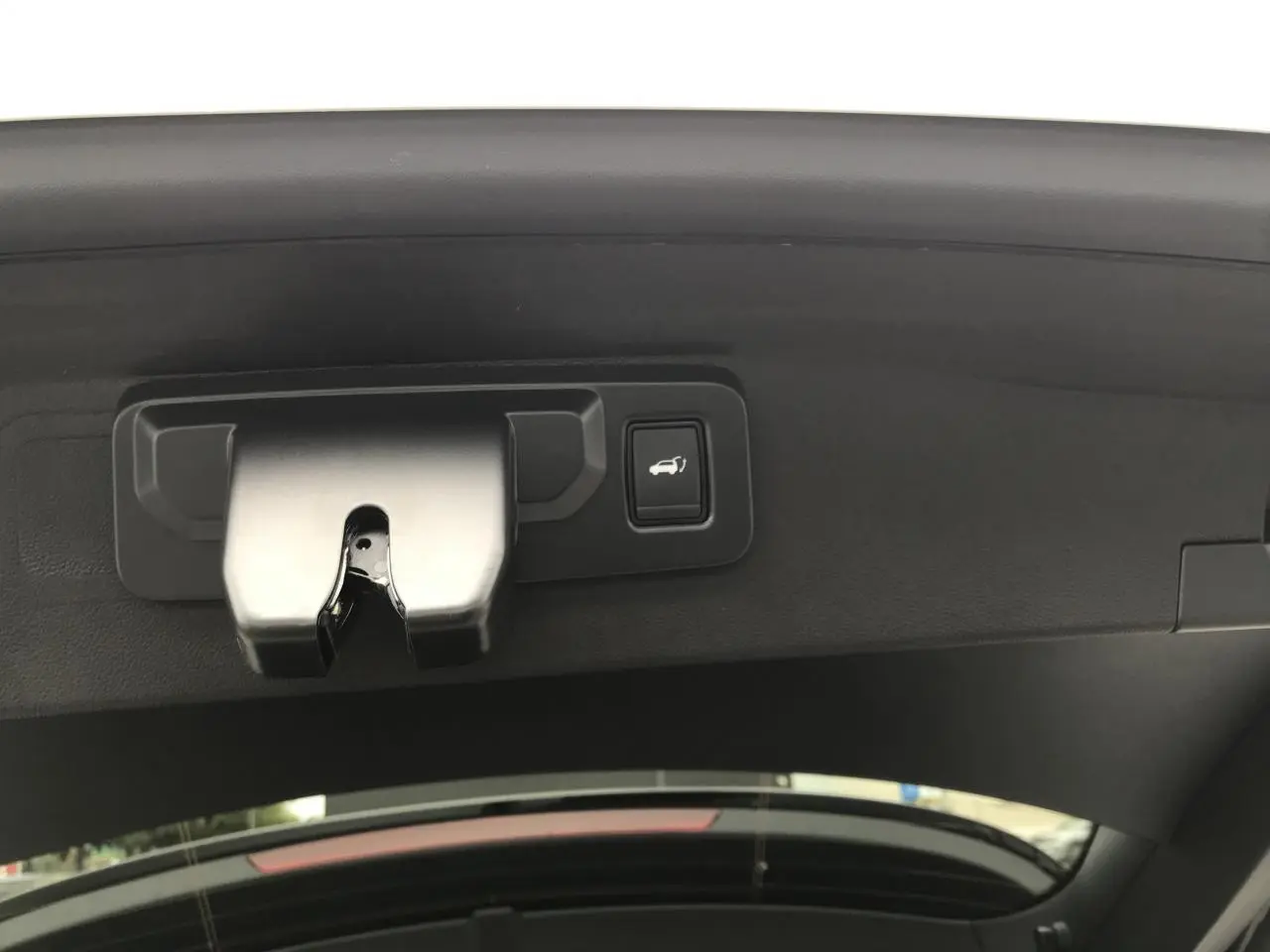 Détail du mécanisme d'ouverture du hayon motorisé blanc Renault Austral 2025 vu de l'intérieur vers le coffre.