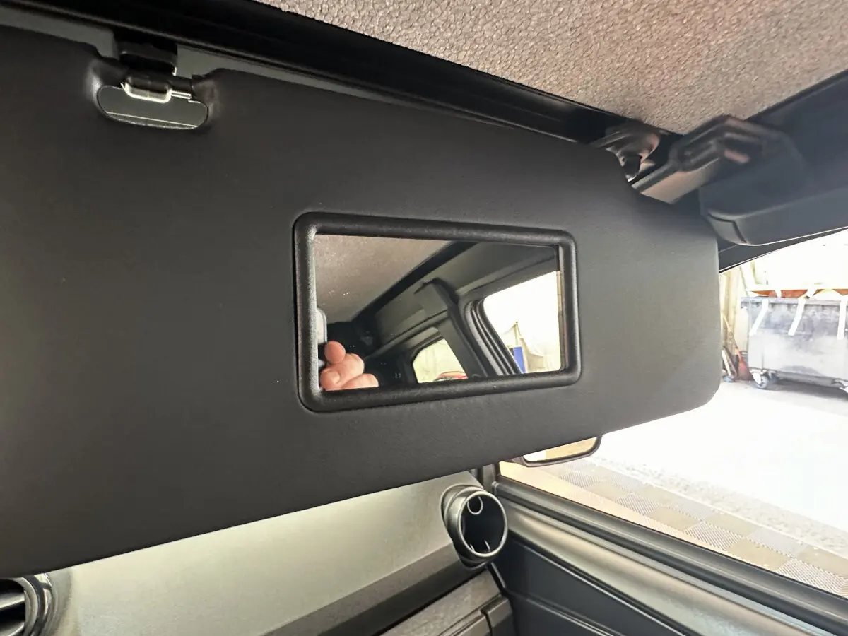 Détail du pare-soleil côté conducteur avec miroir intégré dans l’habitacle d’une Aixam Ambition E City Pack blanche.