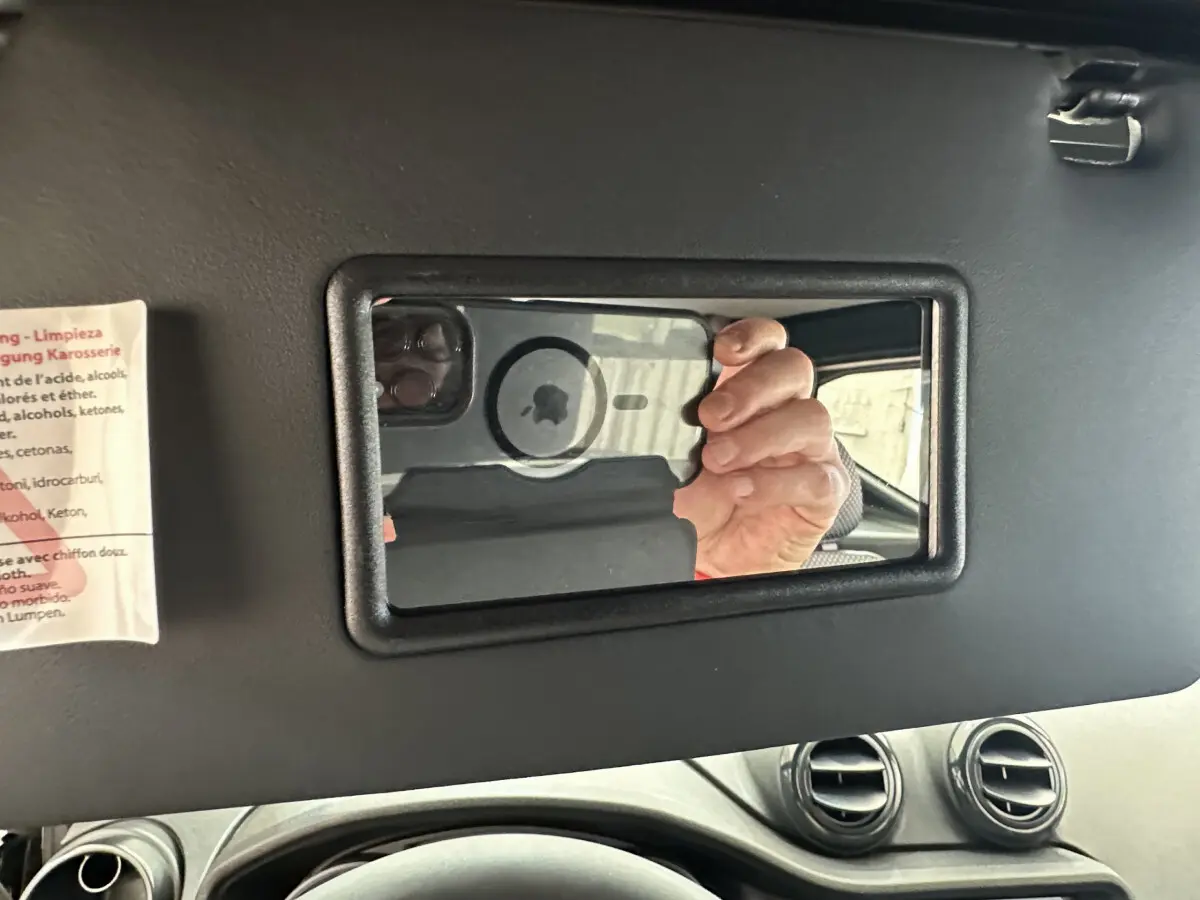 Miroir de courtoisie ouvert sur pare-soleil intérieur d'AIXAM AMBITION E CITY PACK 2026, vue côté conducteur.