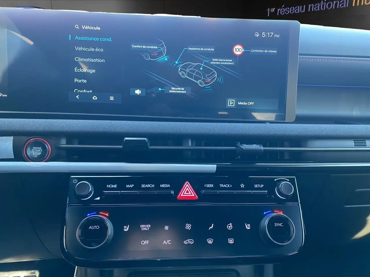 Vue intérieure du tableau de bord du Hyundai Tucson 2025, avec écran tactile et commandes climatisation en noir.