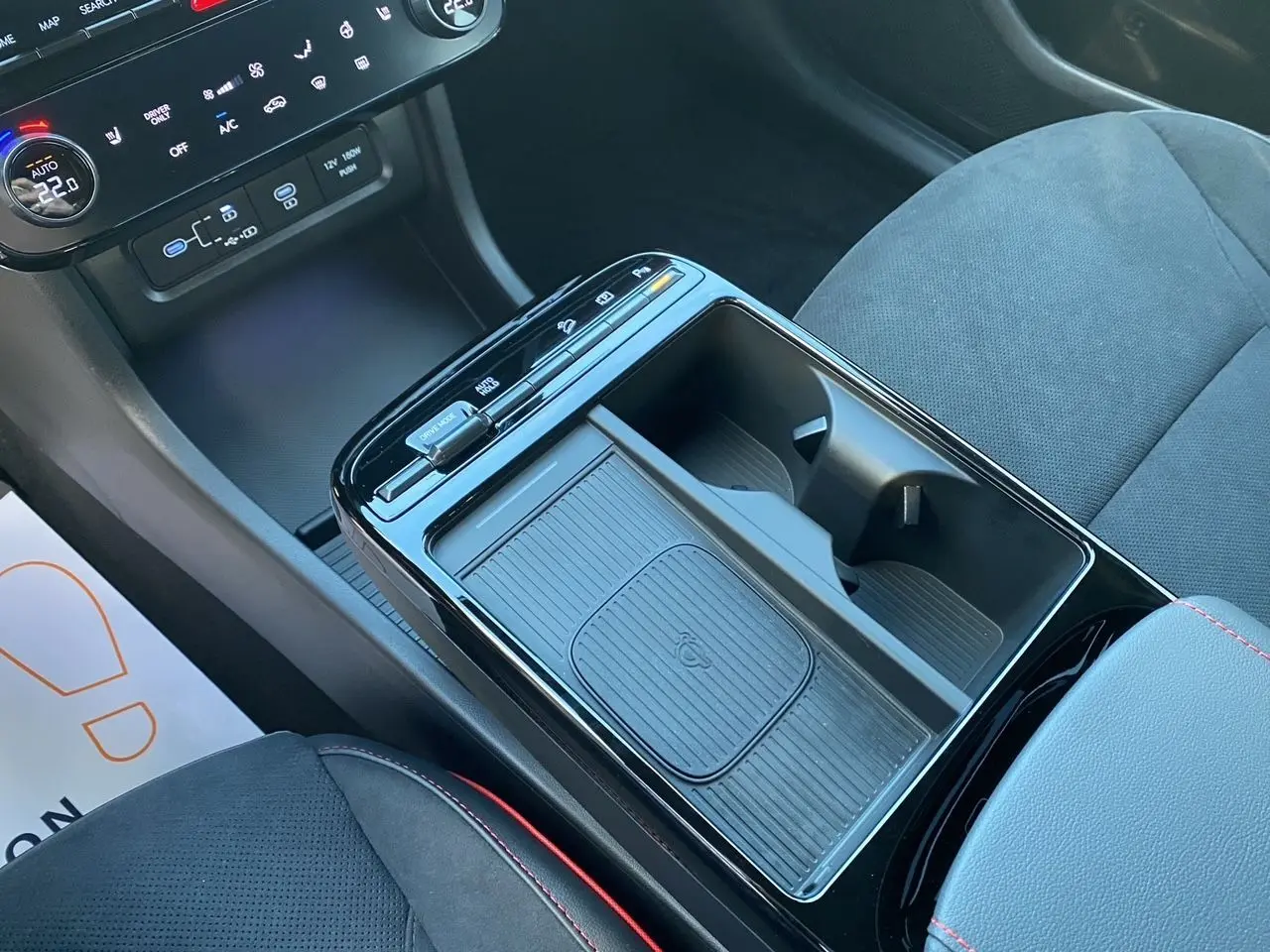 Vue intérieure du Hyundai Tucson 2025 en Abyss Black, focus sur la console centrale avec rangement et commandes tactiles.