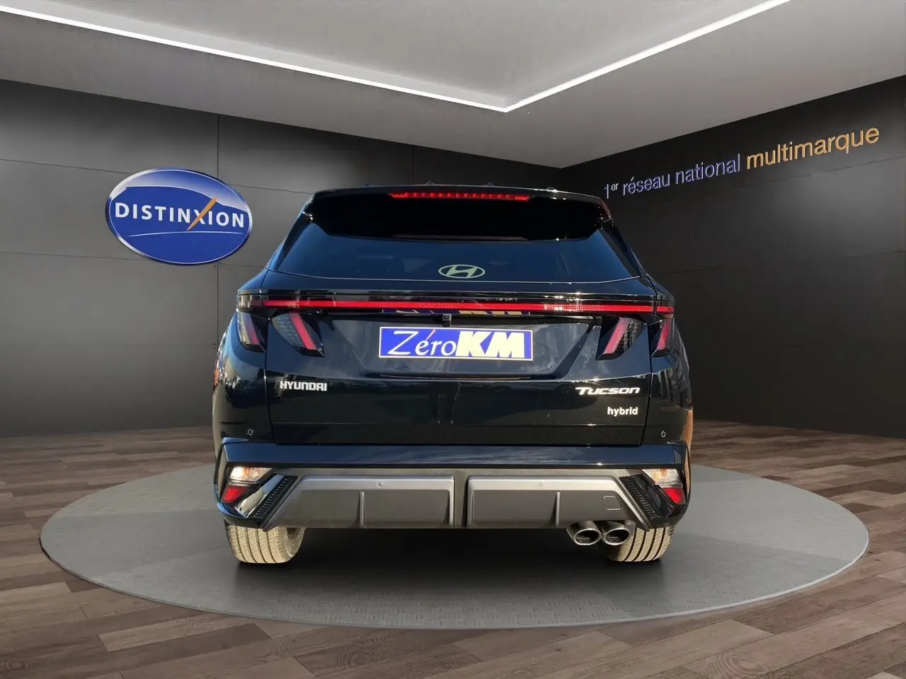 Vue arrière du Hyundai Tucson 1.6 T-GDI hybride noir Abyss, avec feux LED et double sortie d'échappement visible.
