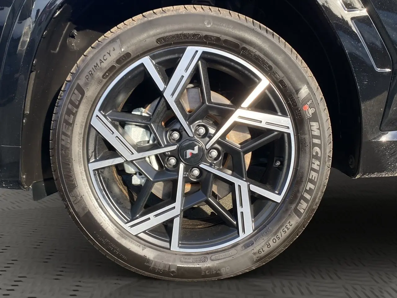 Gros plan sur la jante alliage noire et argentée avec logo N du Hyundai Tucson 2025 couleur Abyss Black.