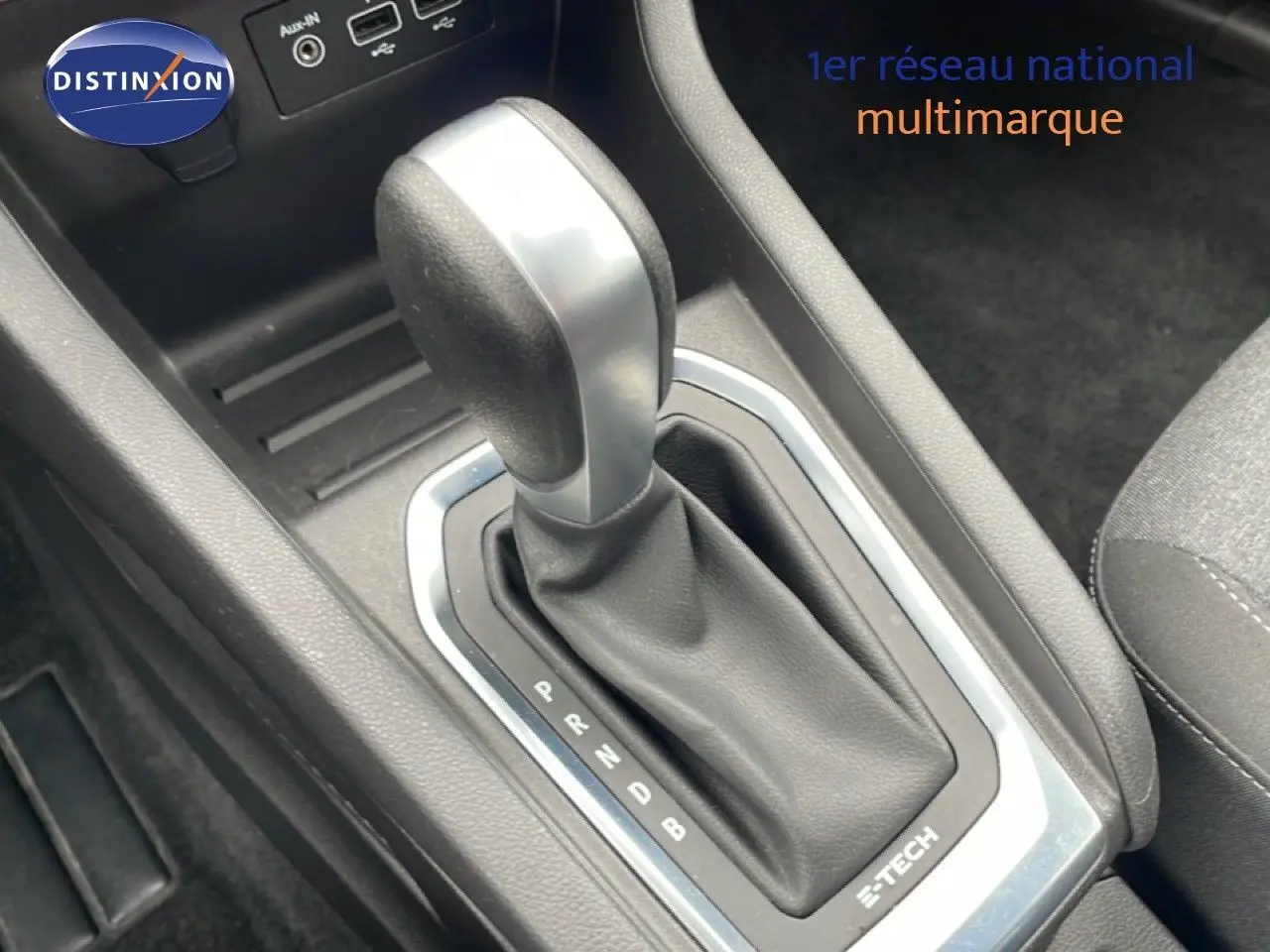 Gros plan sur la commande de boîte automatique de la Renault Clio V 1.6 E-TECH blanche, avec levier en cuir noir.