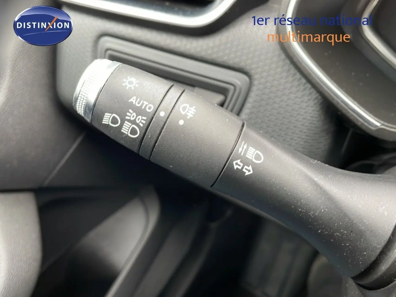 Gros plan sur la commande des phares et clignotants à gauche du volant d'une Renault Clio blanche Glacier 2020.