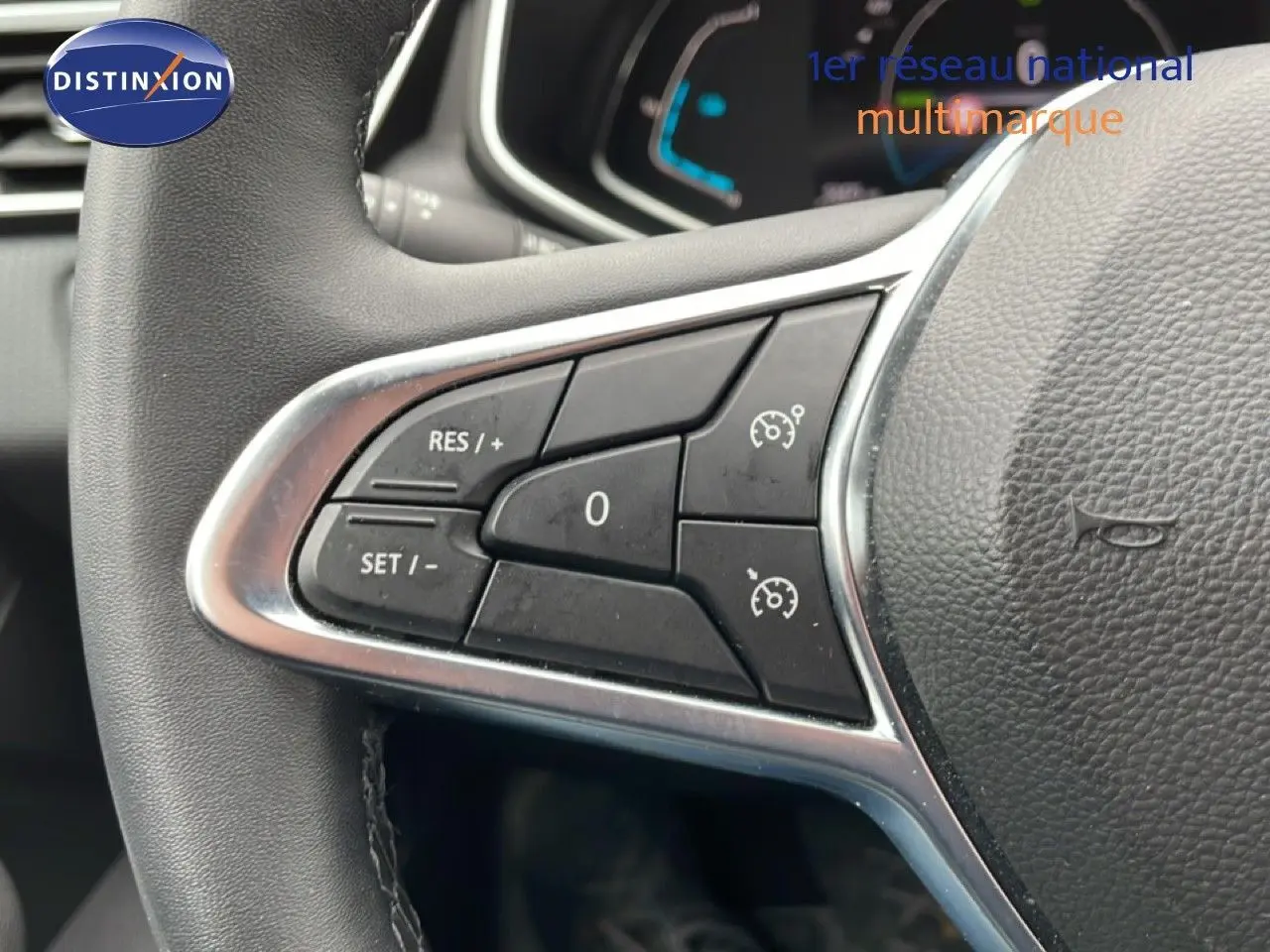 Gros plan sur les commandes de régulateur de vitesse au volant cuir d’une Renault Clio blanche Glacier 2020.
