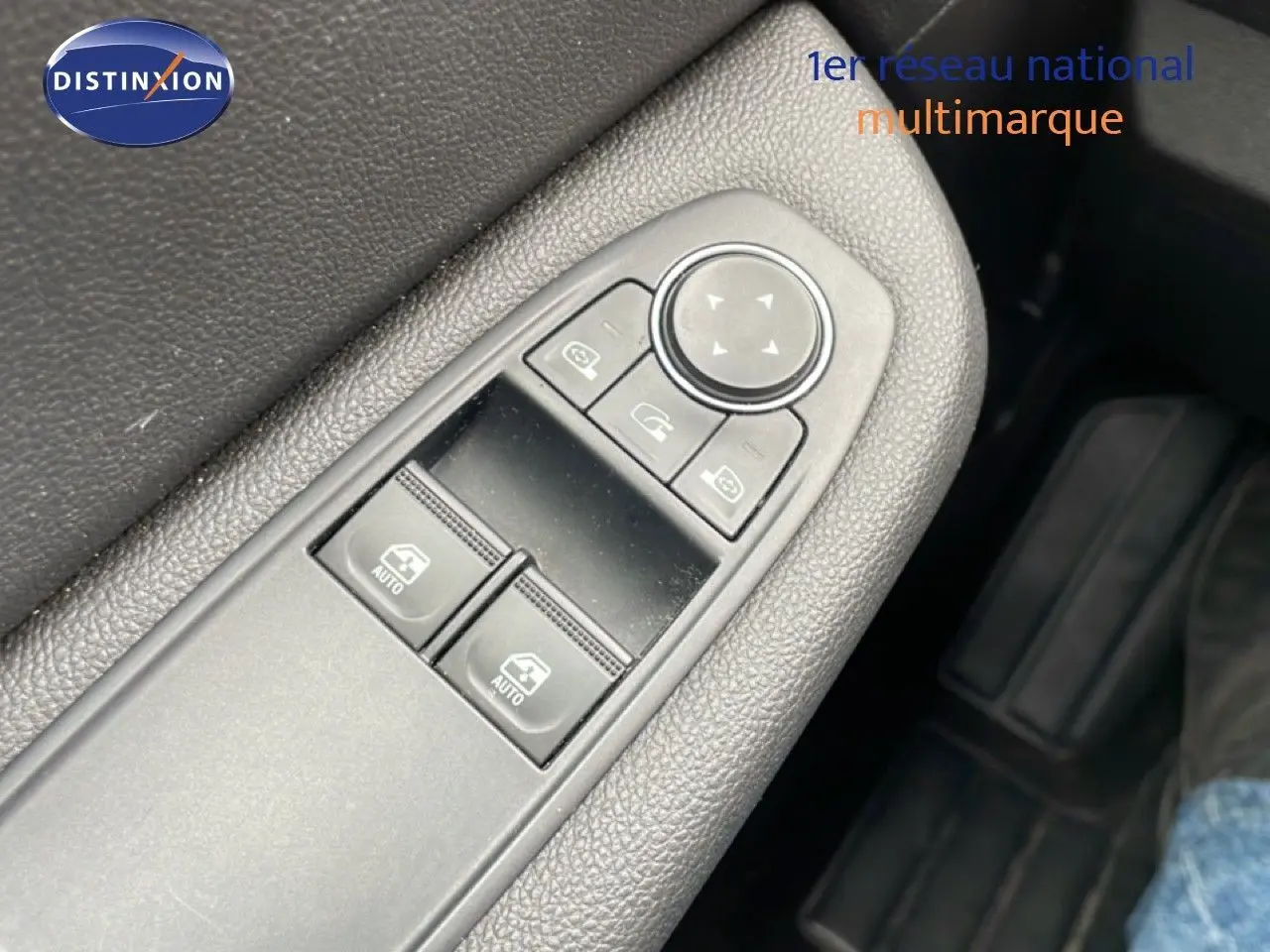 Gros plan sur les commandes des vitres et rétroviseurs côté conducteur d'une Renault Clio blanche Glacier 2020 hybride.