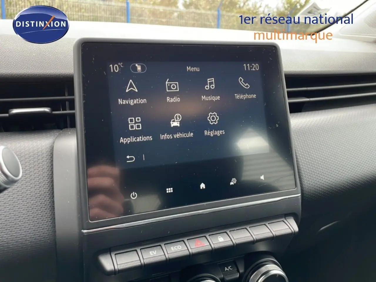 Écran tactile central de la Renault Clio blanc glacier, affichant le menu multimédia avec navigation et radio.