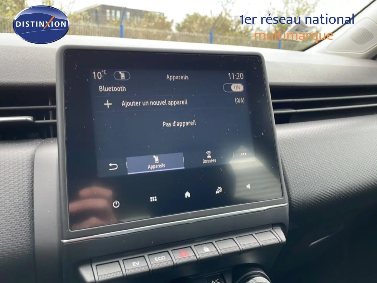 Écran tactile central affichant le menu Bluetooth dans l'habitacle d'une Renault Clio blanche, vue de face rapprochée.