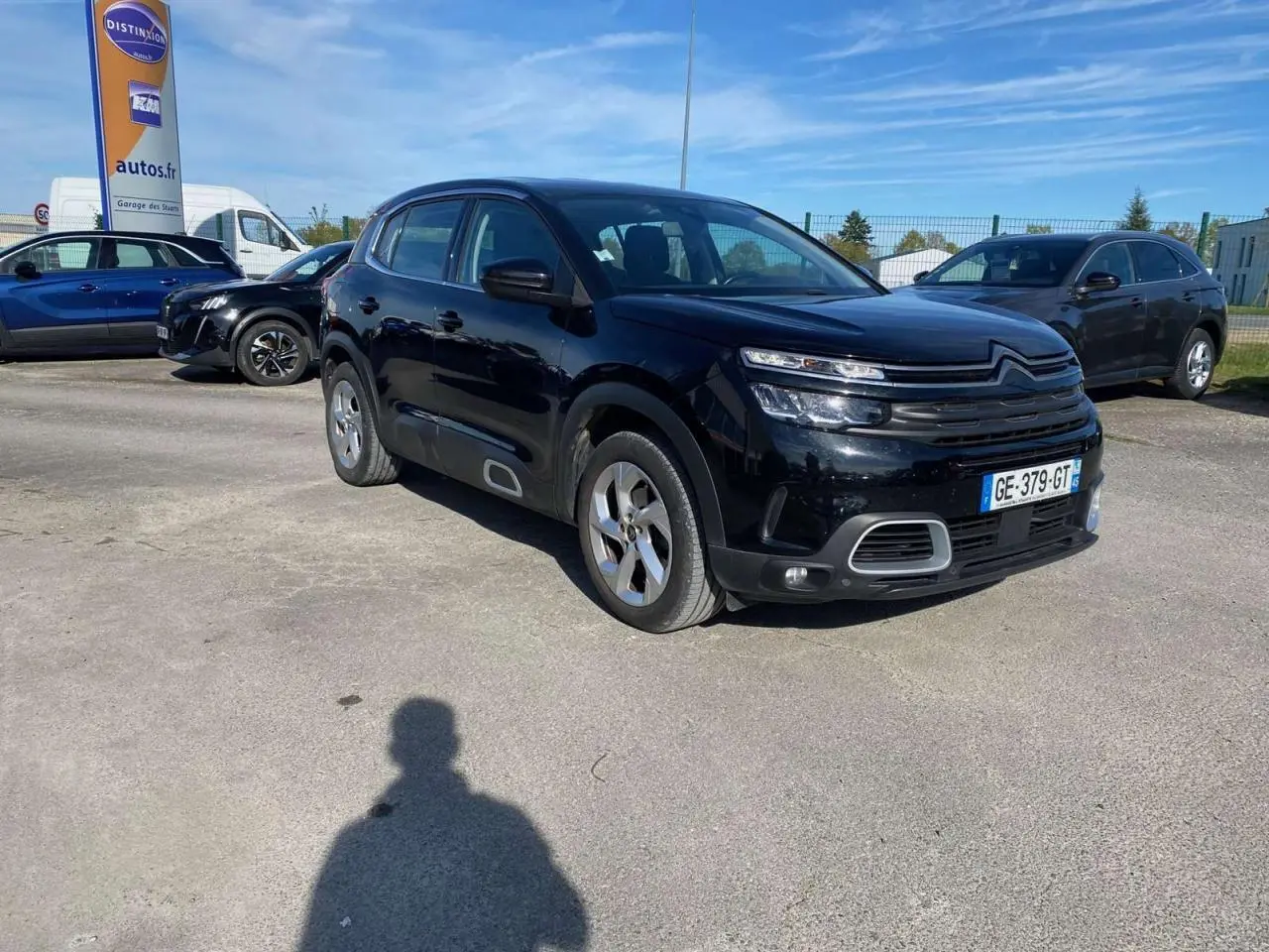 Citroën C5 Aircross noir vue 3/4 avant droit sur parking avec jantes alliage 18 pouces et calandre distinctive.
