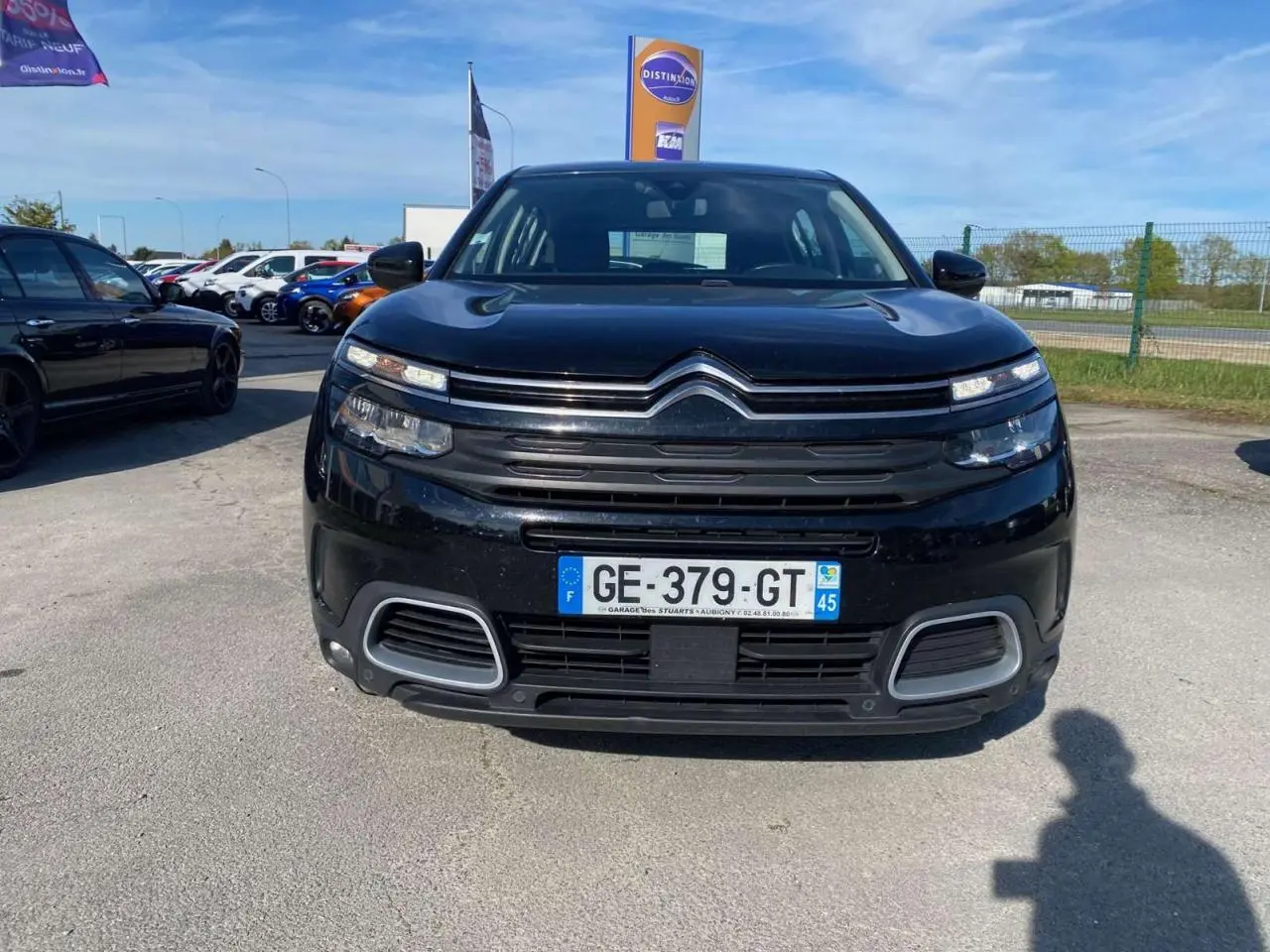 Vue avant d'un Citroën C5 Aircross noir 2021 avec calandre distinctive et feux LED fins sur parking extérieur.