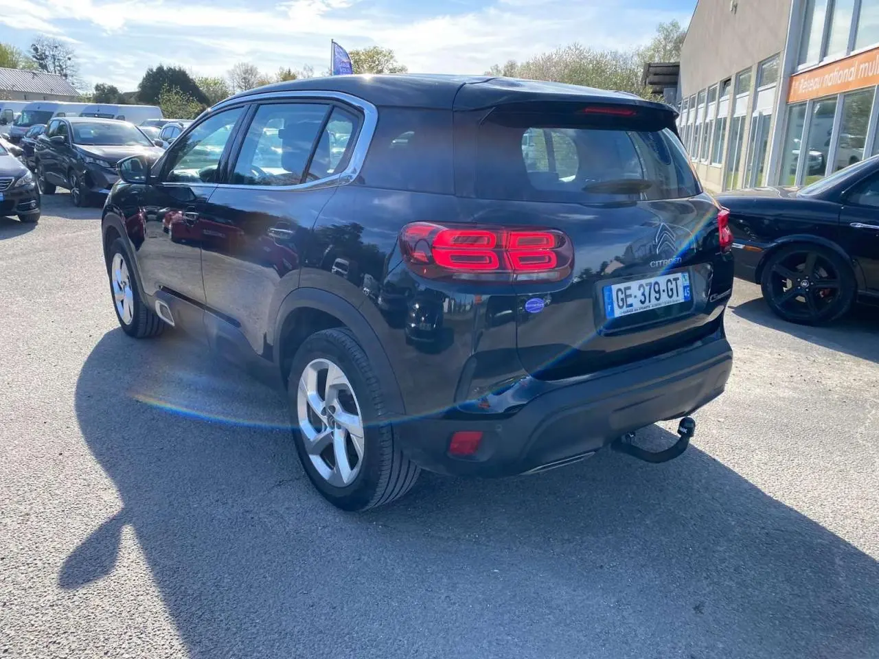 Vue 3/4 arrière droite d’un Citroën C5 Aircross noir avec attelage col de cygne et feux arrière LED 3D visibles.