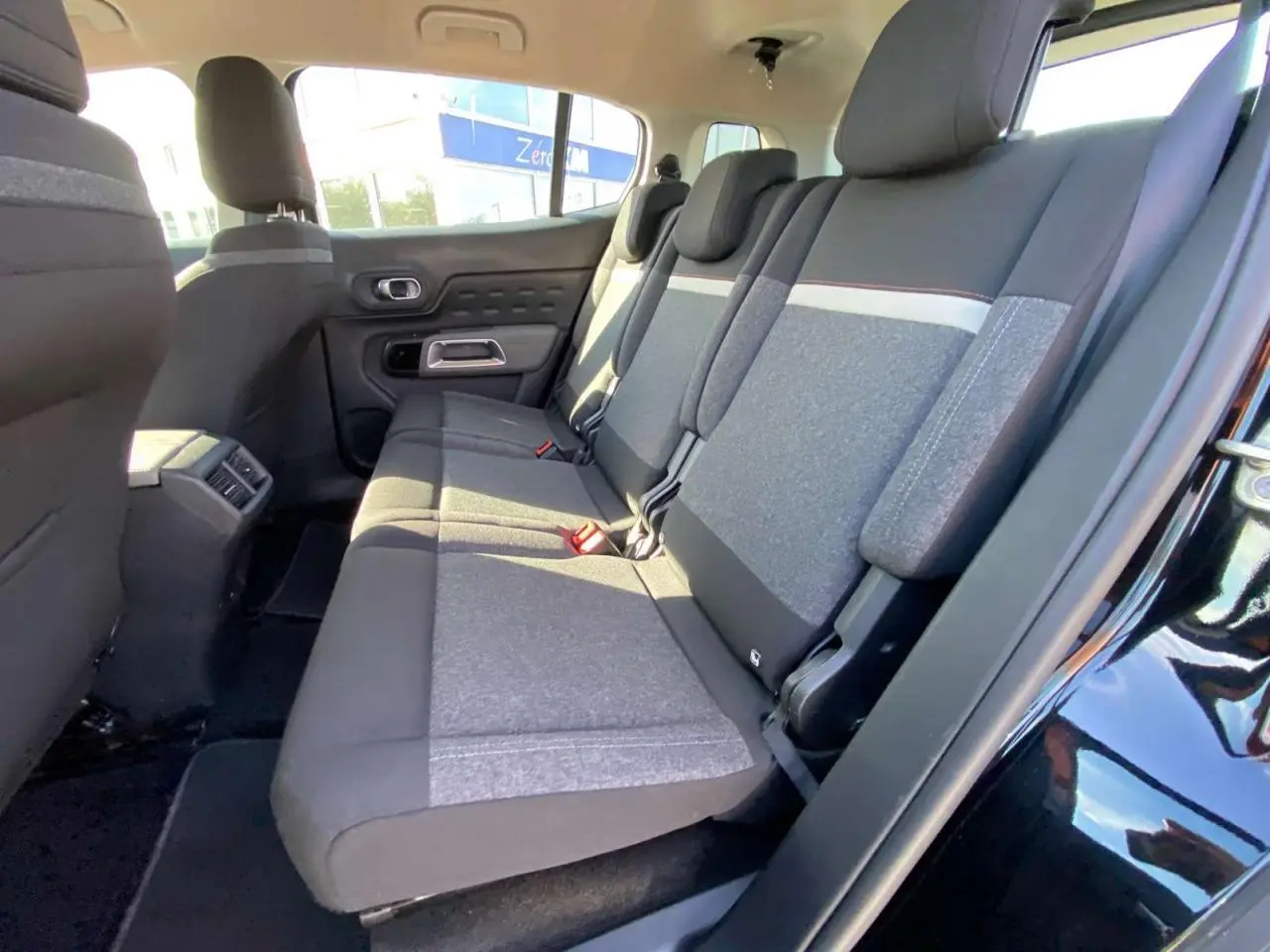 Vue intérieure côté droit des sièges arrière gris et noirs du Citroën C5 Aircross noir avec appuie-têtes et ceinture de sécurité.