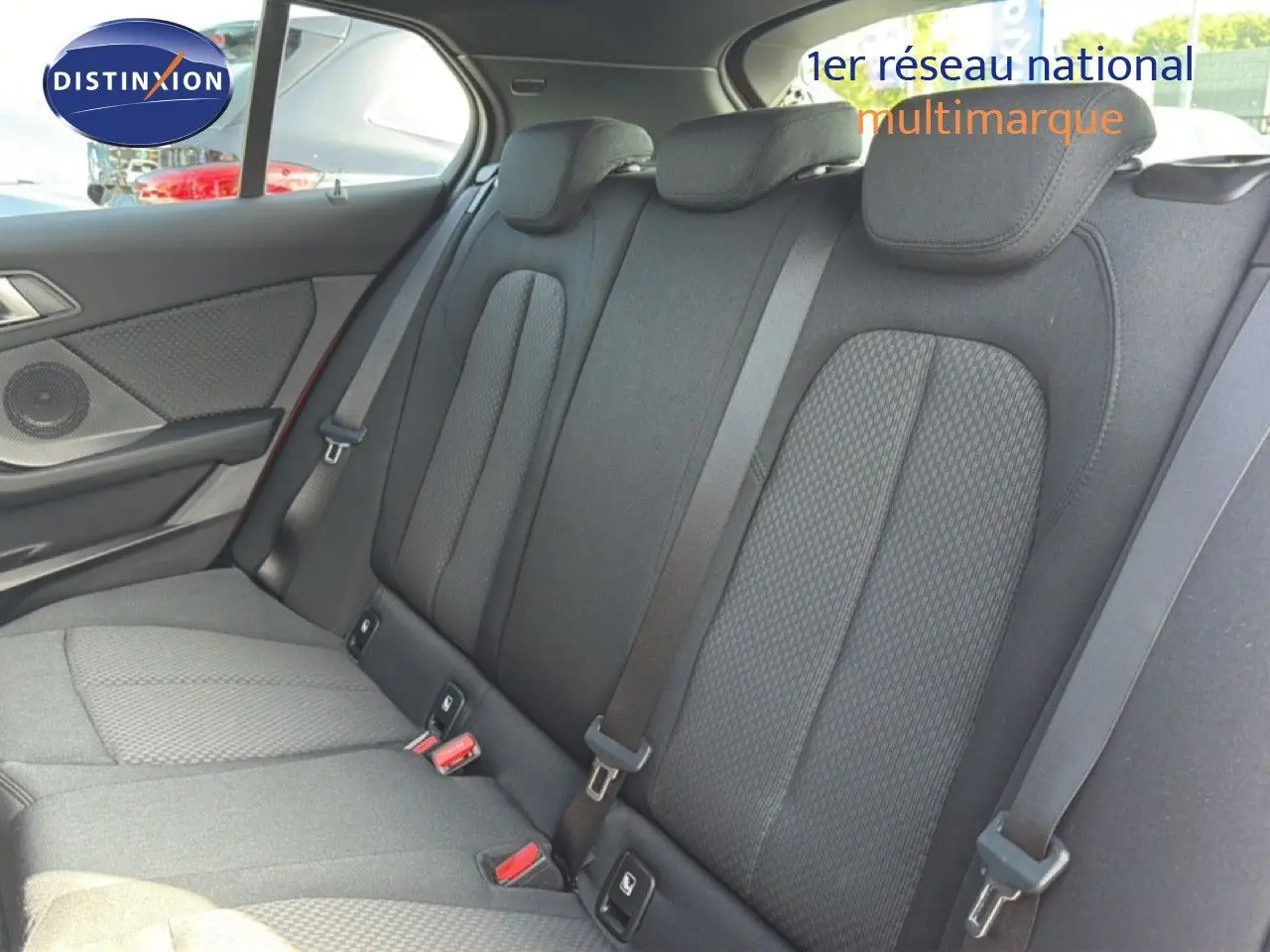 Vue intérieure des sièges arrière en tissu gris foncé de la BMW Série 1 116i Business, avec ceintures de sécurité visibles.