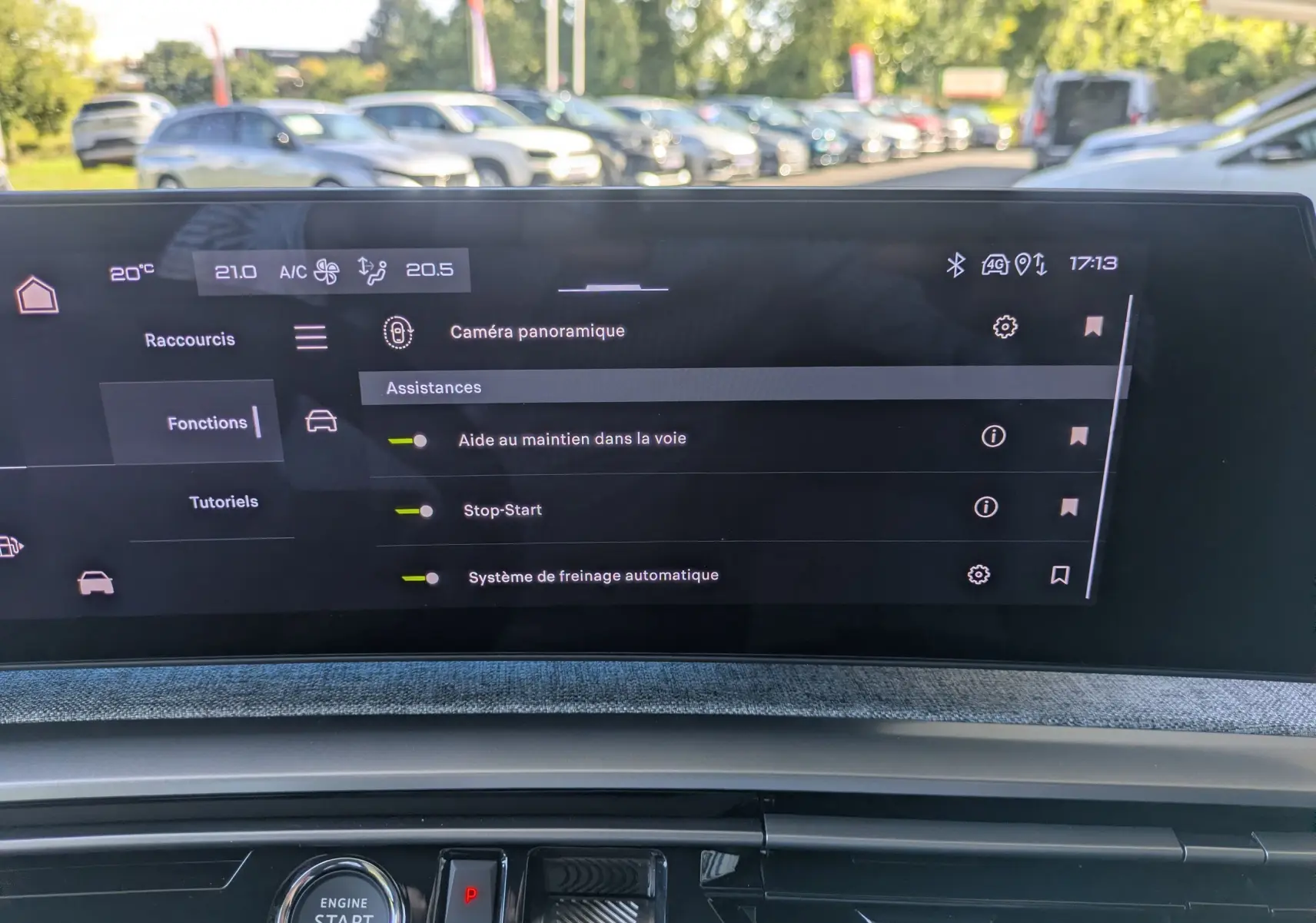 Écran tactile intérieur du Peugeot 3008 Hybrid 145 GT affichant les assistances à la conduite, avec tableau de bord en tissu gris.