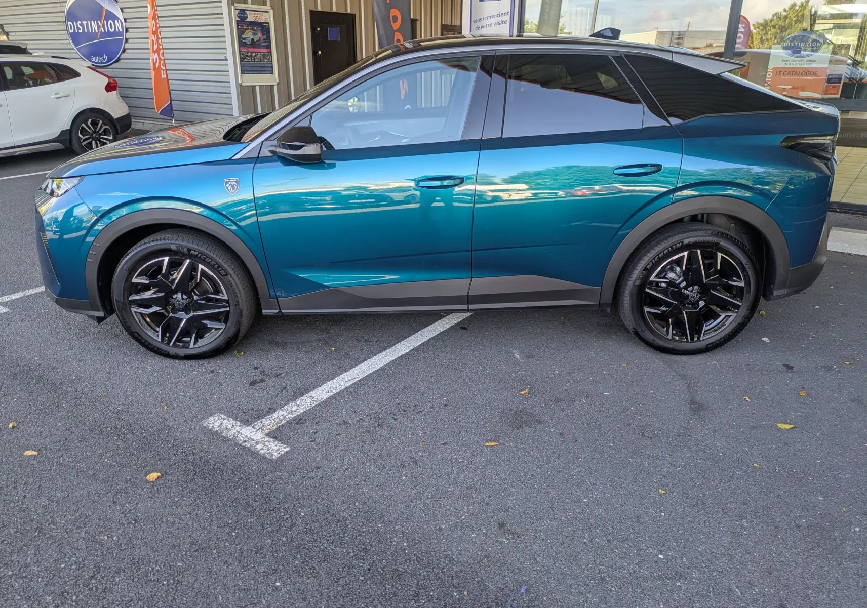 Vue de profil côté gauche du Peugeot 3008 Hybrid 145 GT bleu Obsession avec toit noir et jantes noires brillantes.