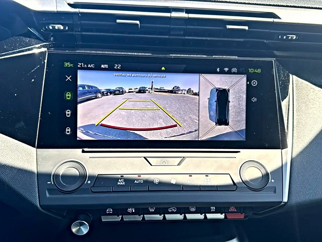 Vue rapprochée de l'écran tactile central du Peugeot 408 Hybrid 145 allure noir, affichant la caméra de recul et la vue à 360°.