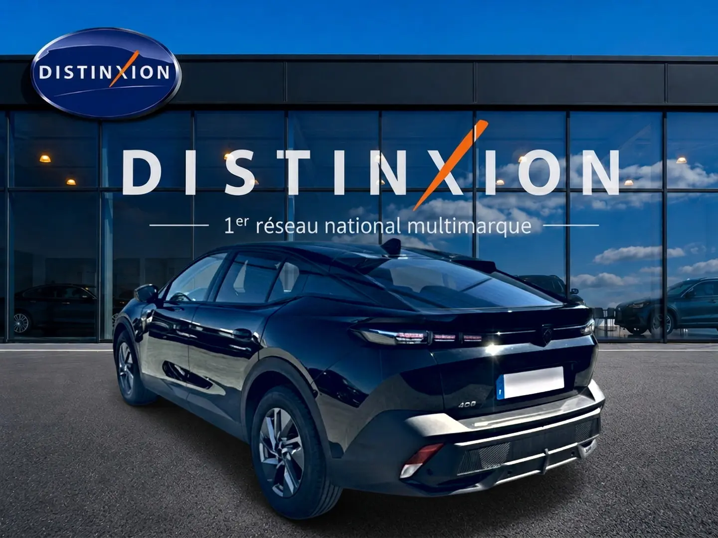 Peugeot 408 Hybrid noir vue 3/4 arrière droit, avec feux arrière LED et jantes alu visibles devant une vitrine Distinxion.