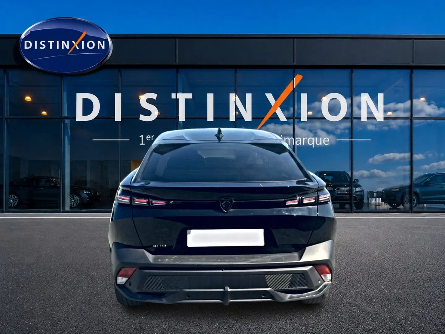 Vue arrière d'une Peugeot 408 Hybrid 145 allure e-dcs6 noire, avec feux LED distinctifs et lunette arrière surteintée.