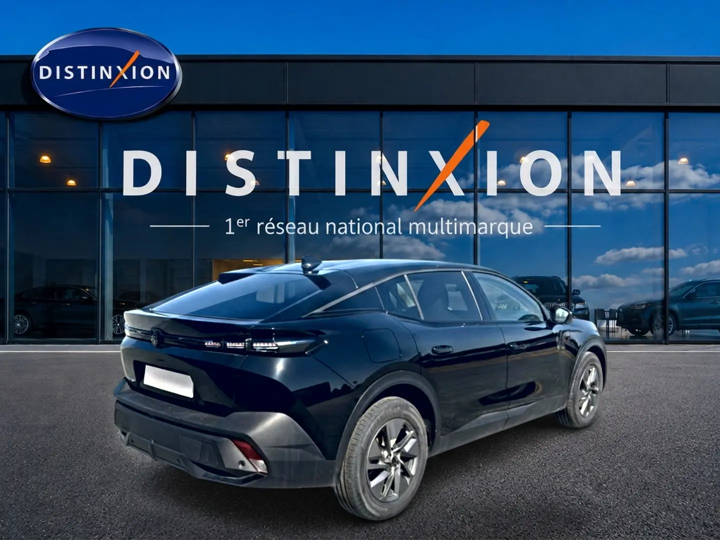 Vue 3/4 arrière droite d'une Peugeot 408 Hybrid 145 allure noire, avec feux arrière LED et jantes alu visibles.