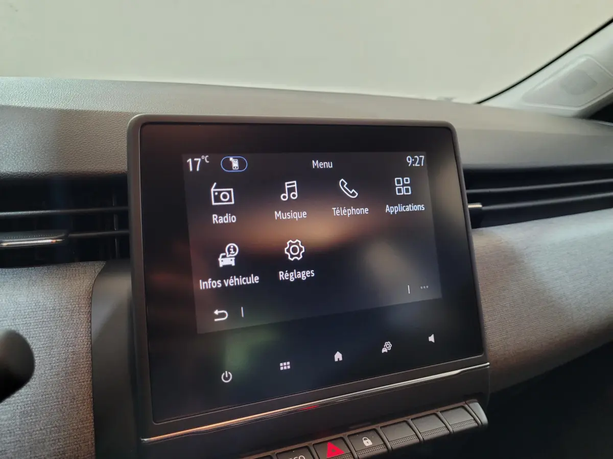 Écran tactile central de la Renault Clio gris foncé, vue rapprochée du tableau de bord côté passager.