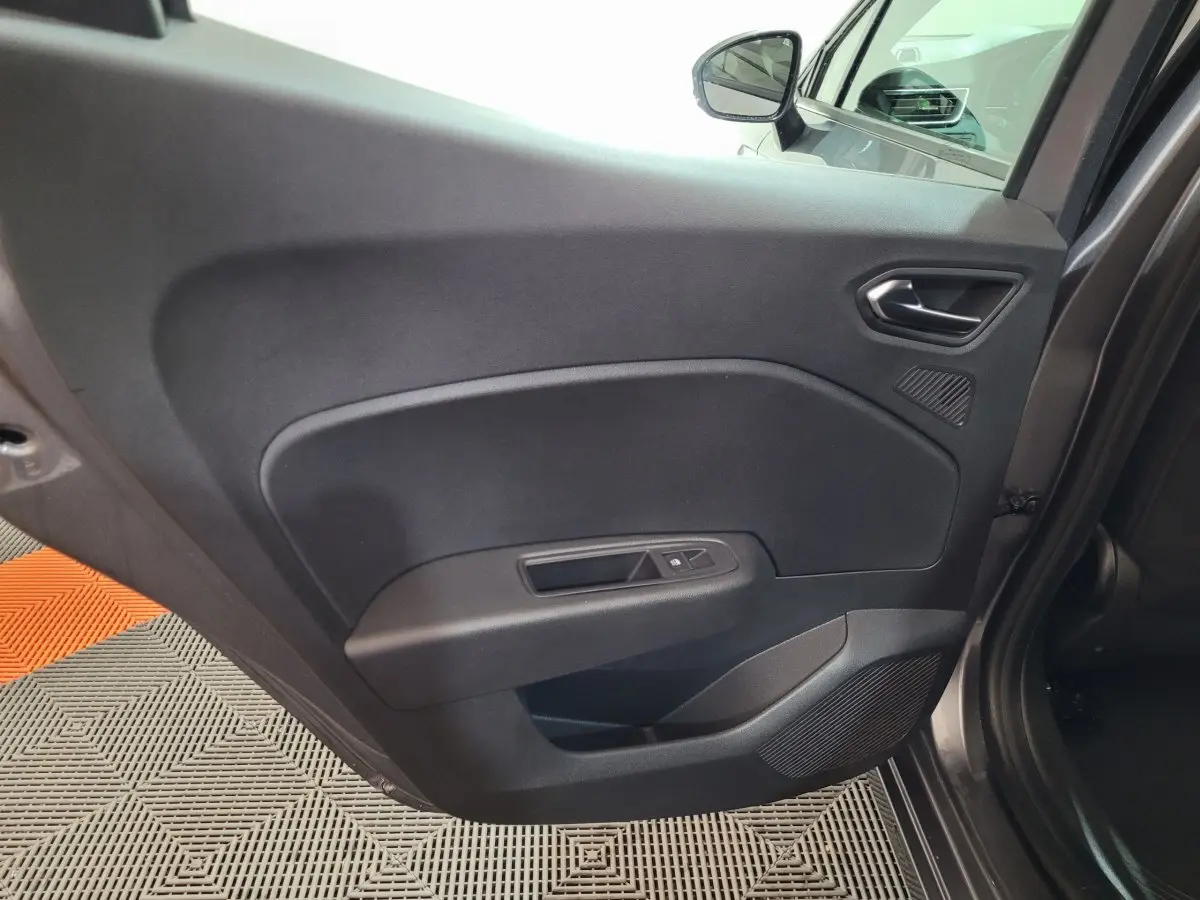 Vue intérieure sur la porte arrière gauche gris foncé de la Renault Clio Evolution Blue dCi 100 avec commande de vitre.