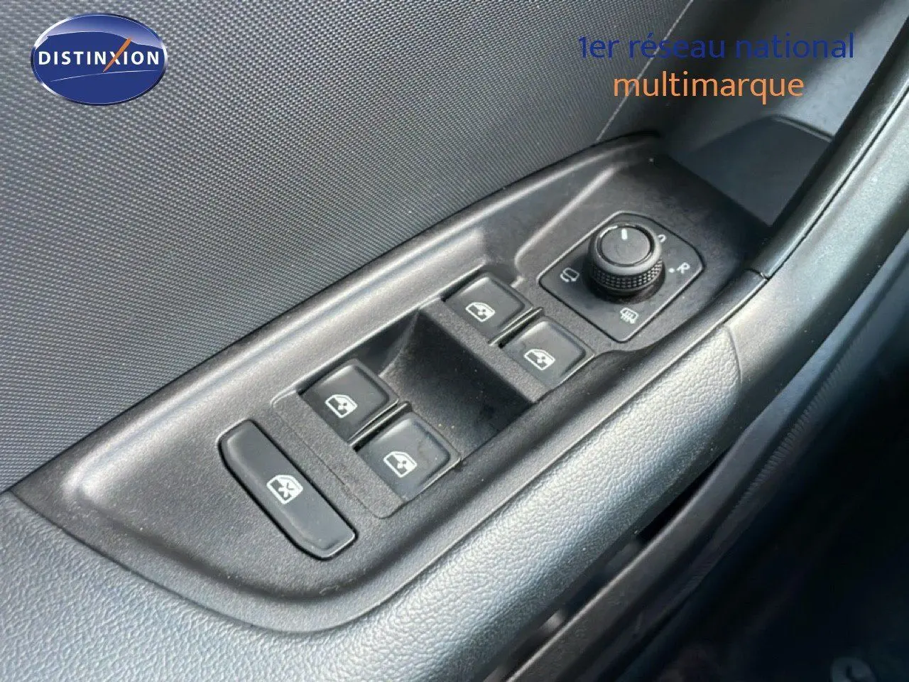 Gros plan sur les commandes de lève-vitres et réglage des rétroviseurs côté conducteur d'une Audi A1 Sportback blanche.