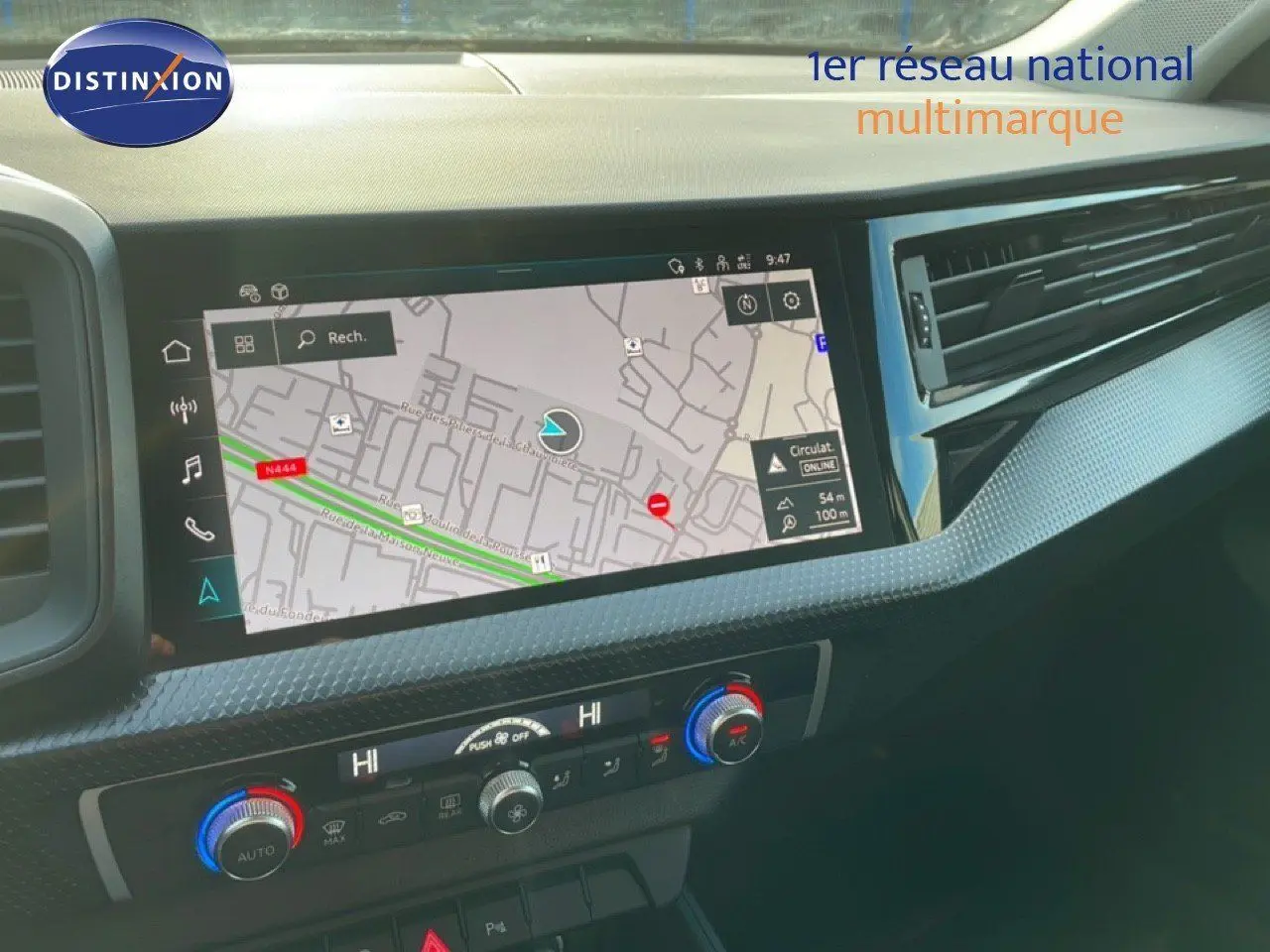 Tableau de bord de l'Audi A1 Sportback 2023 avec écran tactile de navigation et commandes de climatisation en gros plan.