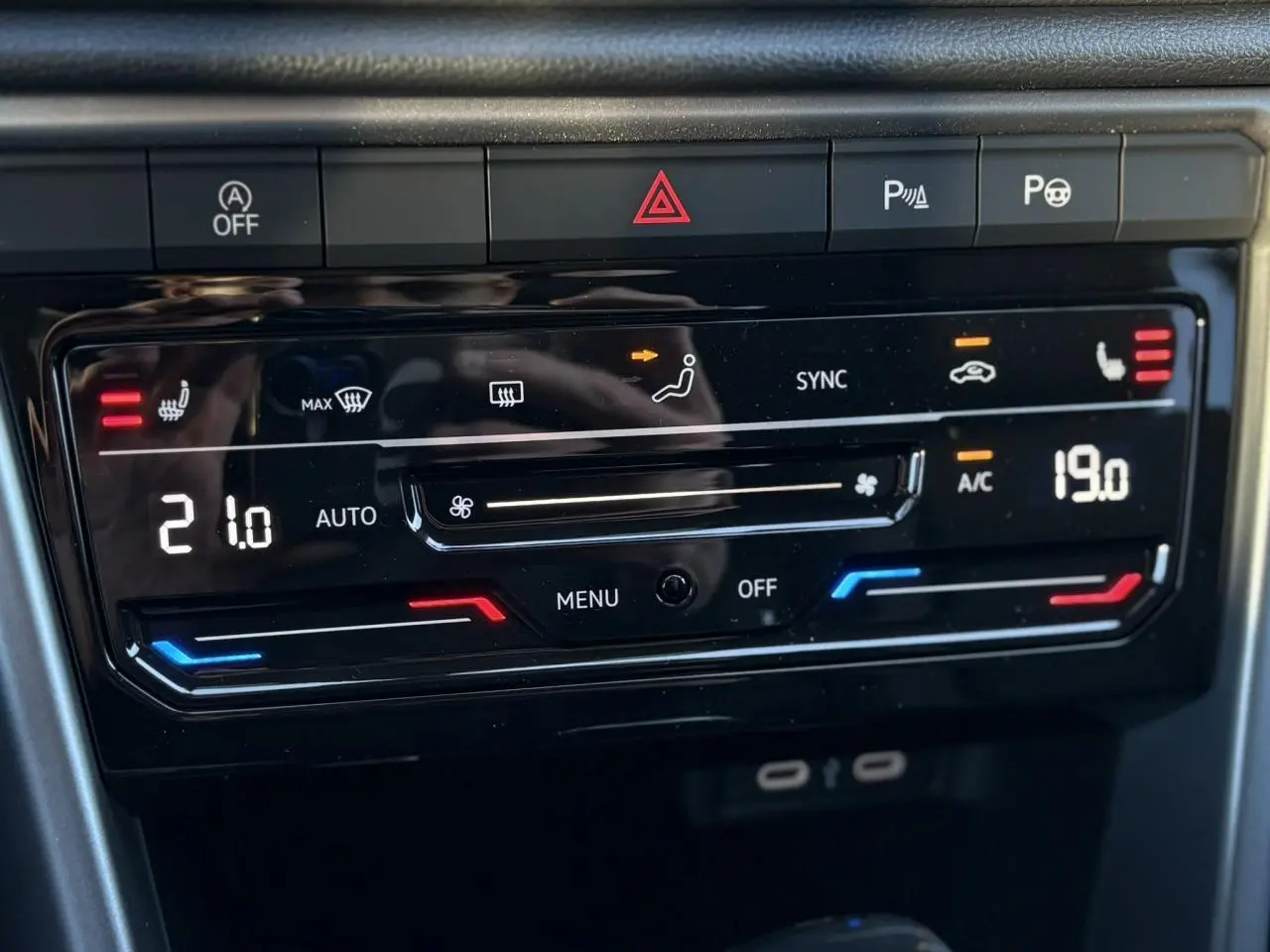 Vue rapprochée de la commande de climatisation bi-zone digitale du Volkswagen T-Roc gris Indium, avec affichage des températures.