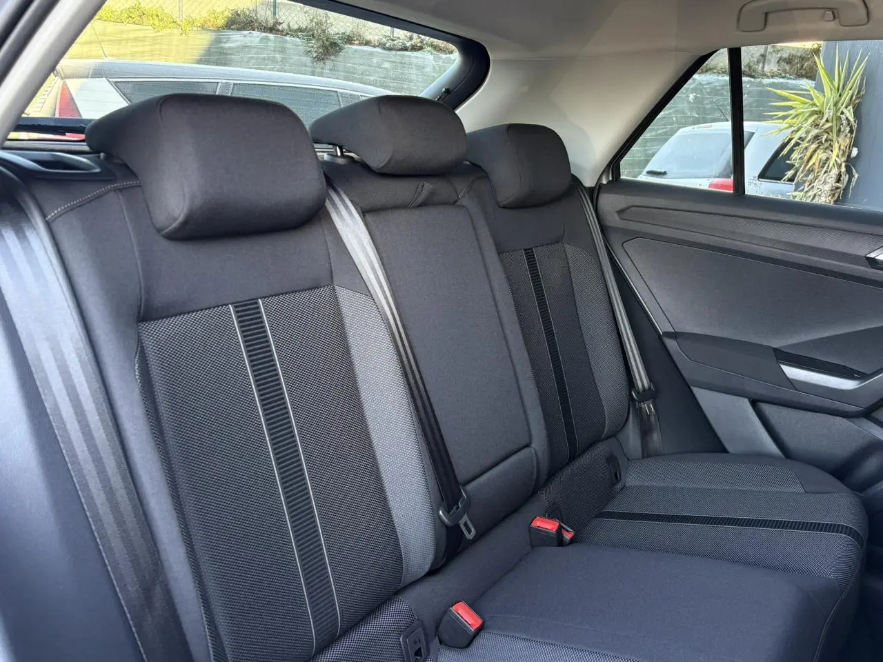 Vue latérale intérieure des sièges arrière noirs du Volkswagen T-Roc 1.5 TSI 150 DSG Life 30 Years, tissu et ceintures visibles.