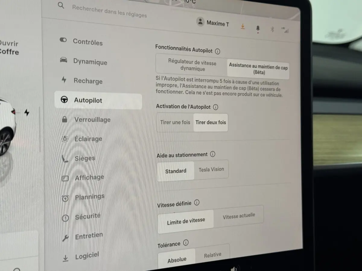 Écran tactile central de la Tesla Model Y blanc, affichant les réglages du système Autopilot.