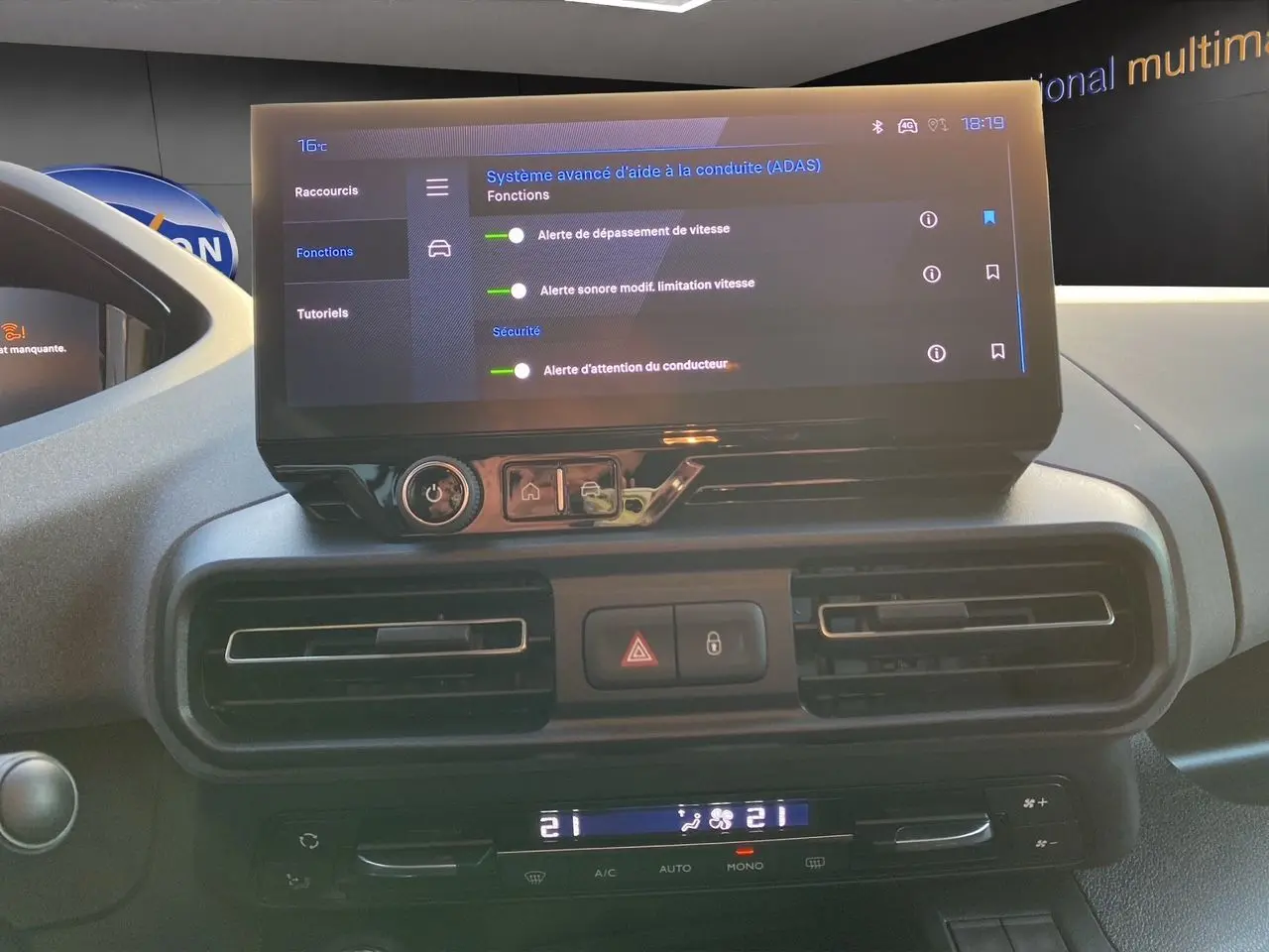 Écran tactile central affichant les aides à la conduite du Peugeot Rifter gris acier, vue intérieure frontale.