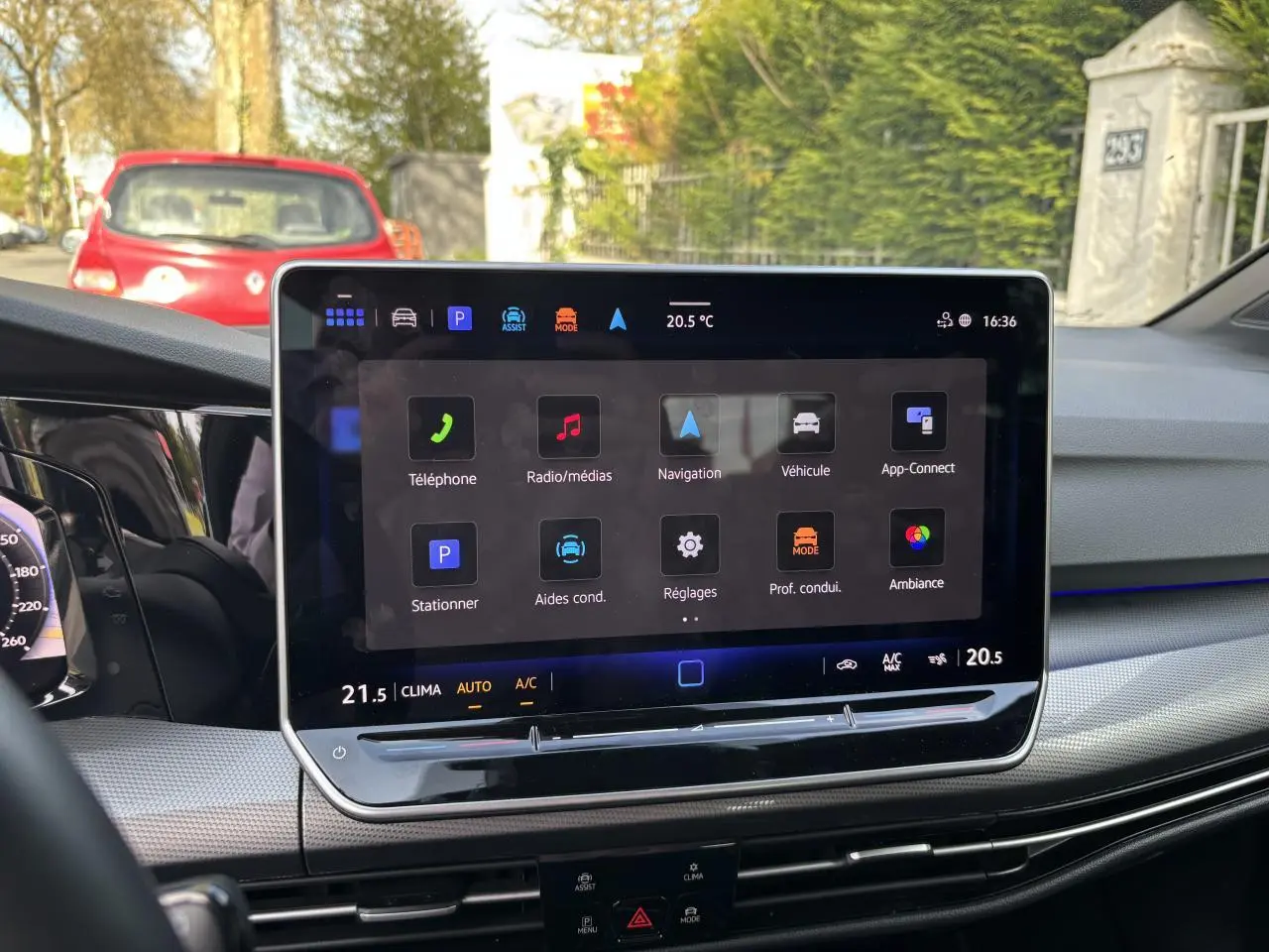 Écran tactile central de la Volkswagen Golf 2024 blanc, vue intérieure du tableau de bord côté conducteur.