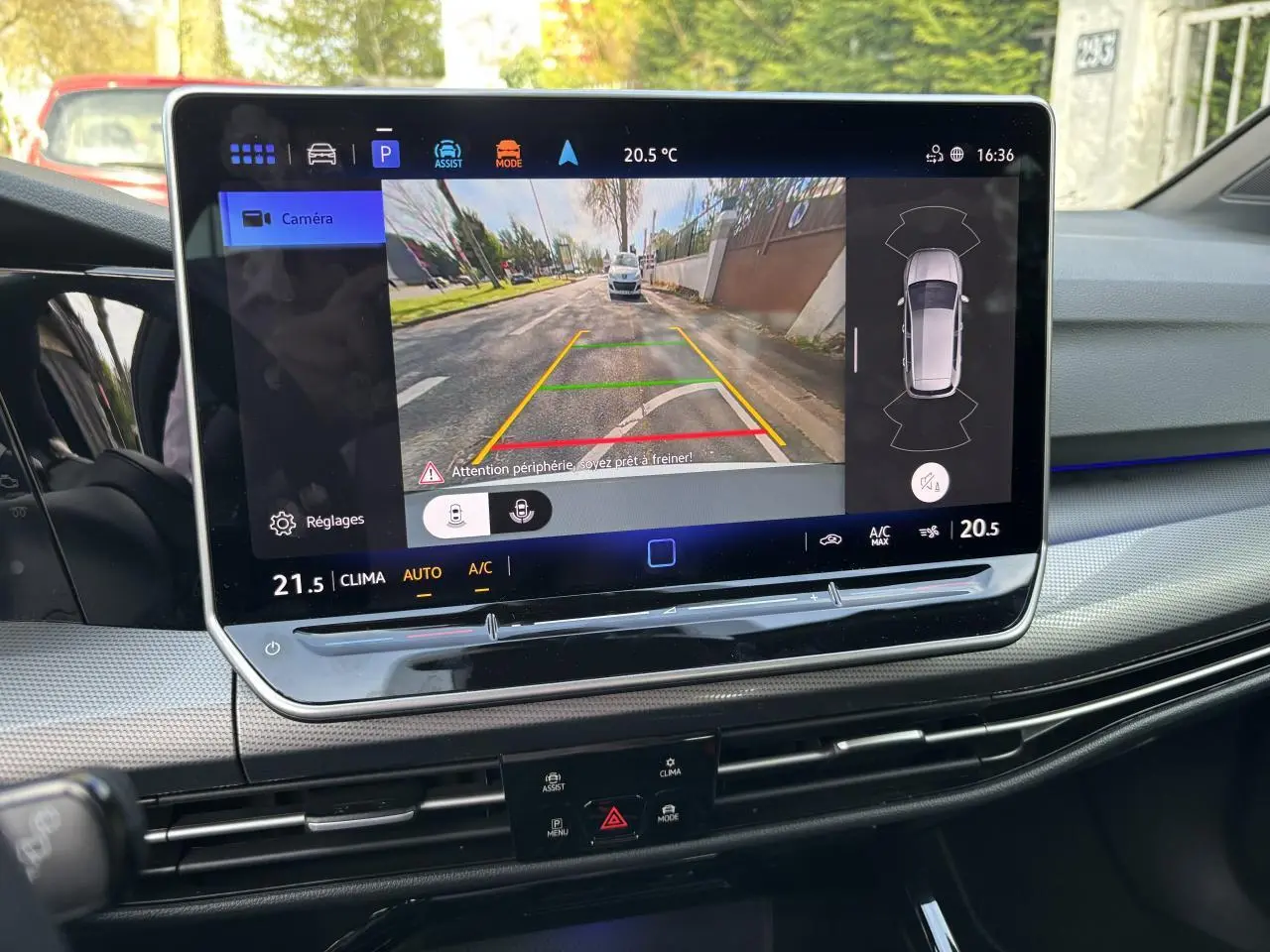 Écran tactile intérieur de la Volkswagen Golf 2024 blanc montrant la caméra de recul avec guidage de trajectoire.