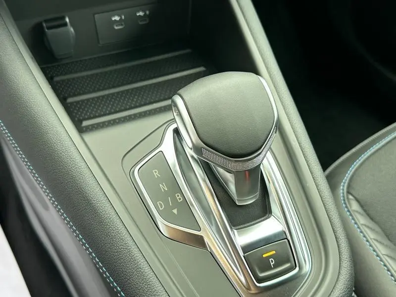 Le levier de vitesses automatique du Renault Captur 2025 en gros plan, avec coutures bleues sur le cuir noir.
