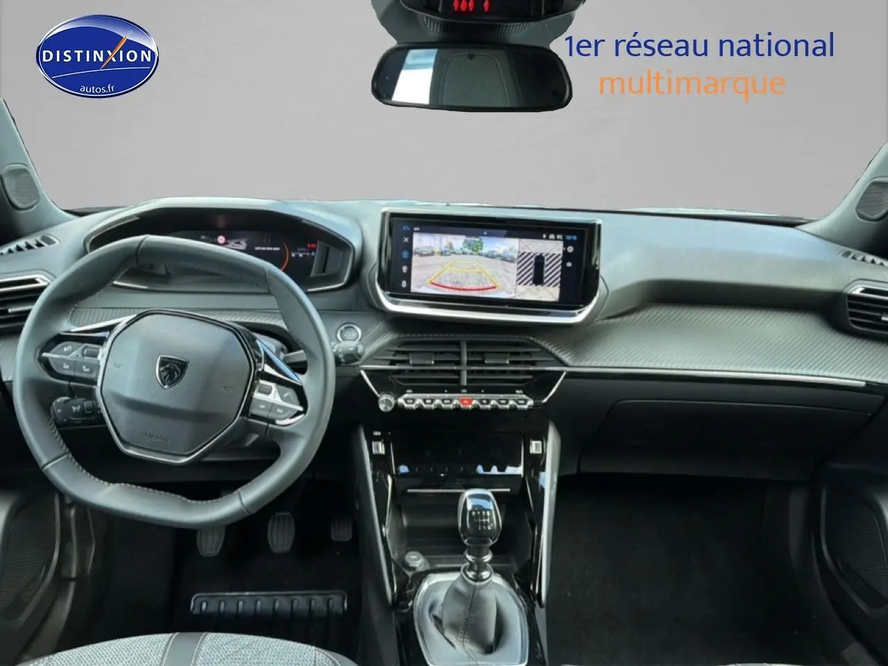 Vue intérieure avant du Peugeot 2008 1.2 100 allure gris artense, mettant en valeur le volant multifonction et l'écran tactile central.