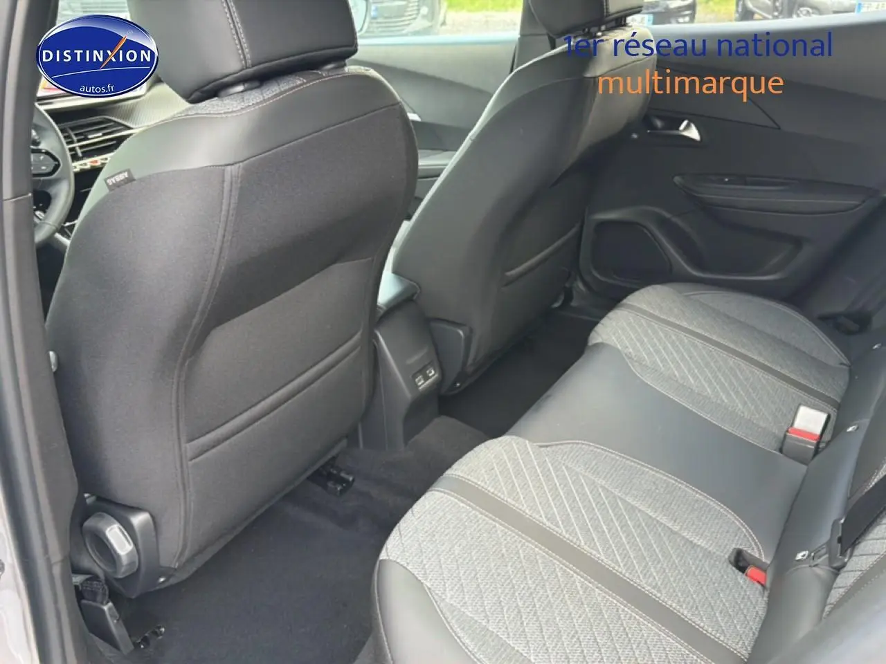 Vue arrière intérieure du Peugeot 2008 gris Artense, mettant en valeur la banquette arrière en tissu et cuir embossé.