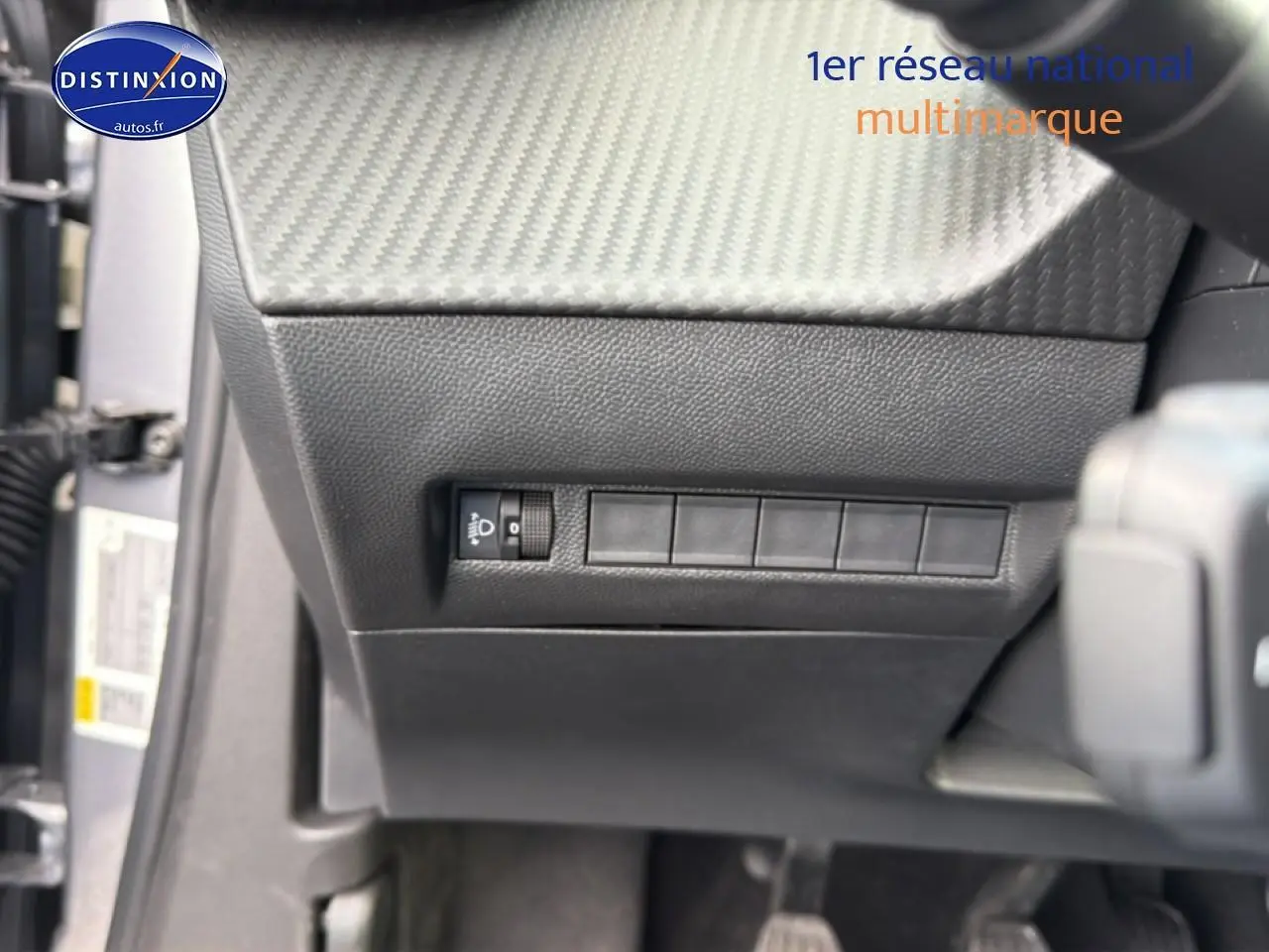 Vue intérieure côté gauche du tableau de bord noir texturé avec commande de réglage des phares sur Peugeot 2008 2025 gris artense