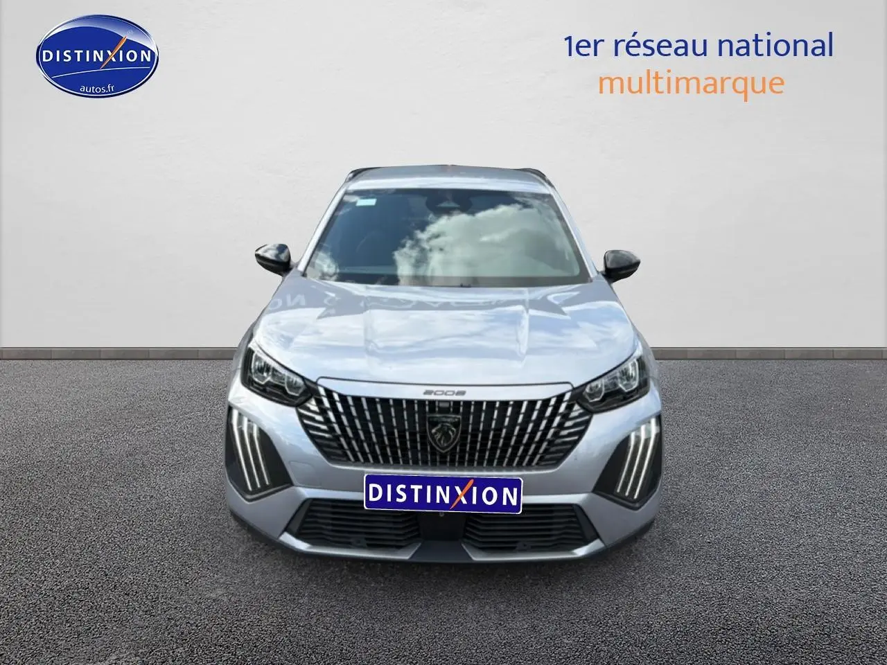 Vue frontale d'un Peugeot 2008 gris artense 2025 avec calandre verticale et feux LED distinctifs.