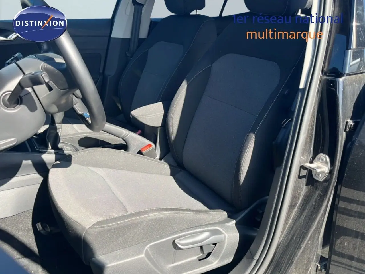 Vue intérieure côté conducteur de la SKODA FABIA 2025 noire, montrant les sièges en tissu gris et la boîte manuelle.