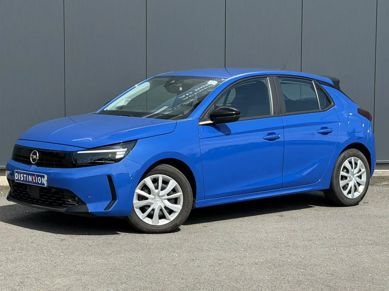 Opel Corsa 2025 bleu Voltaic vue 3/4 avant droit avec phares LED et rétroviseurs noirs électriques rabattables.